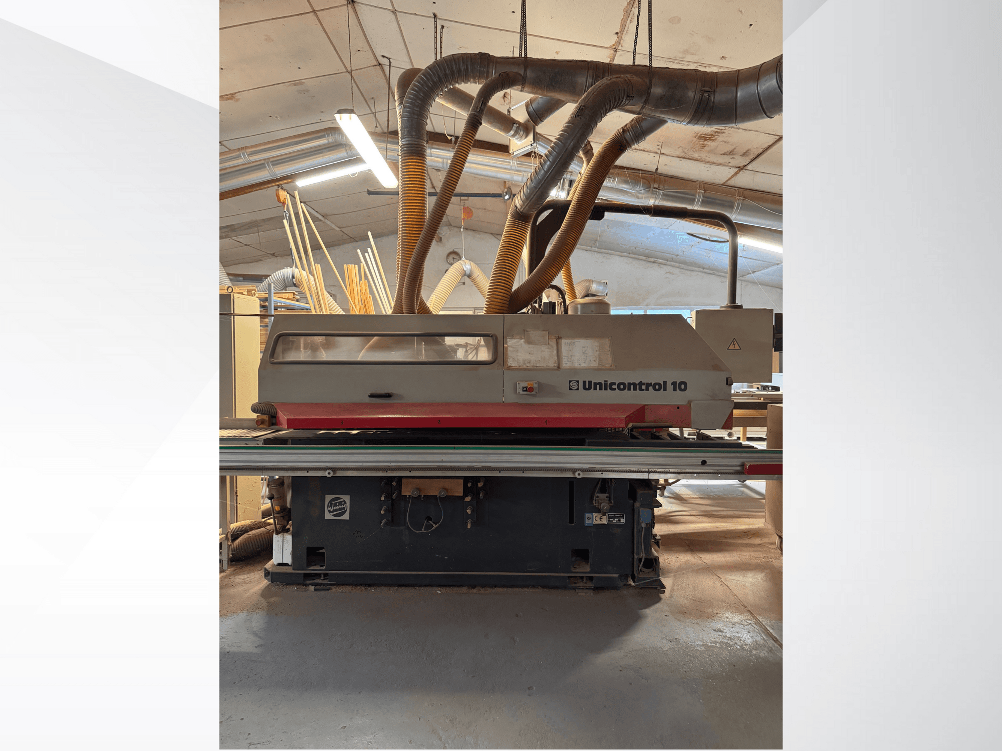 Widok z przodu maszyny do obróbki drewna Unicontrol 10 z rurami odpylającymi i elementami sterującymi.