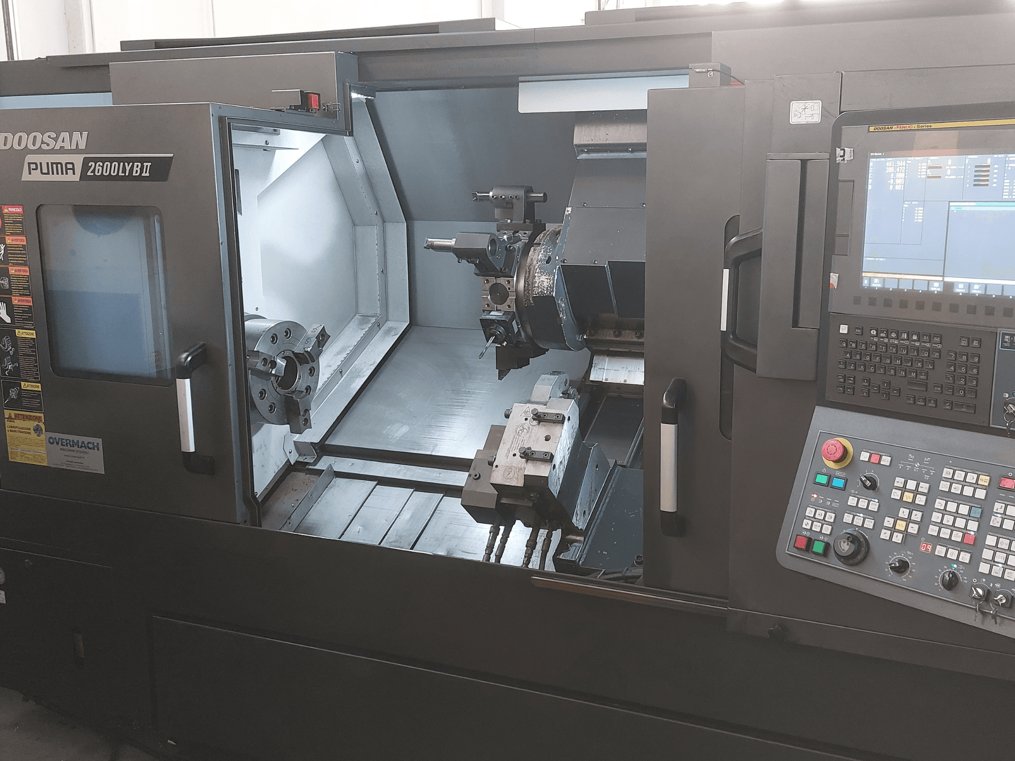 Tokarka pozioma DOOSAN Puma 2600 LYB II w widoku z przodu, prezentująca wnętrze z uchwytem wiertarskim, uchwytem narzędziowym i panelem sterowania.
