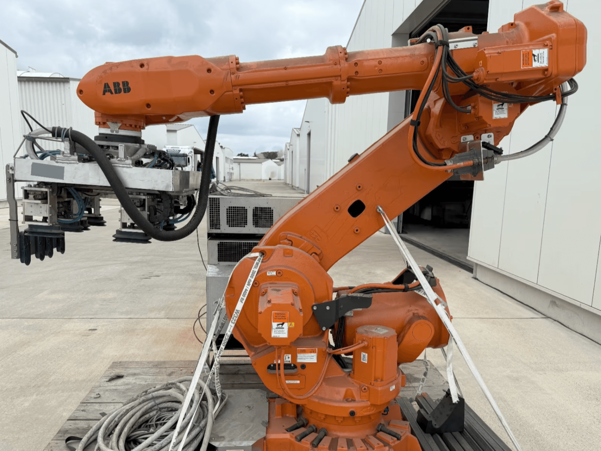 Ramię robota ABB RB 6600-130/3.2 w widoku z boku, z pomarańczowym ramieniem robota z chwytakiem i widocznym okablowaniem.