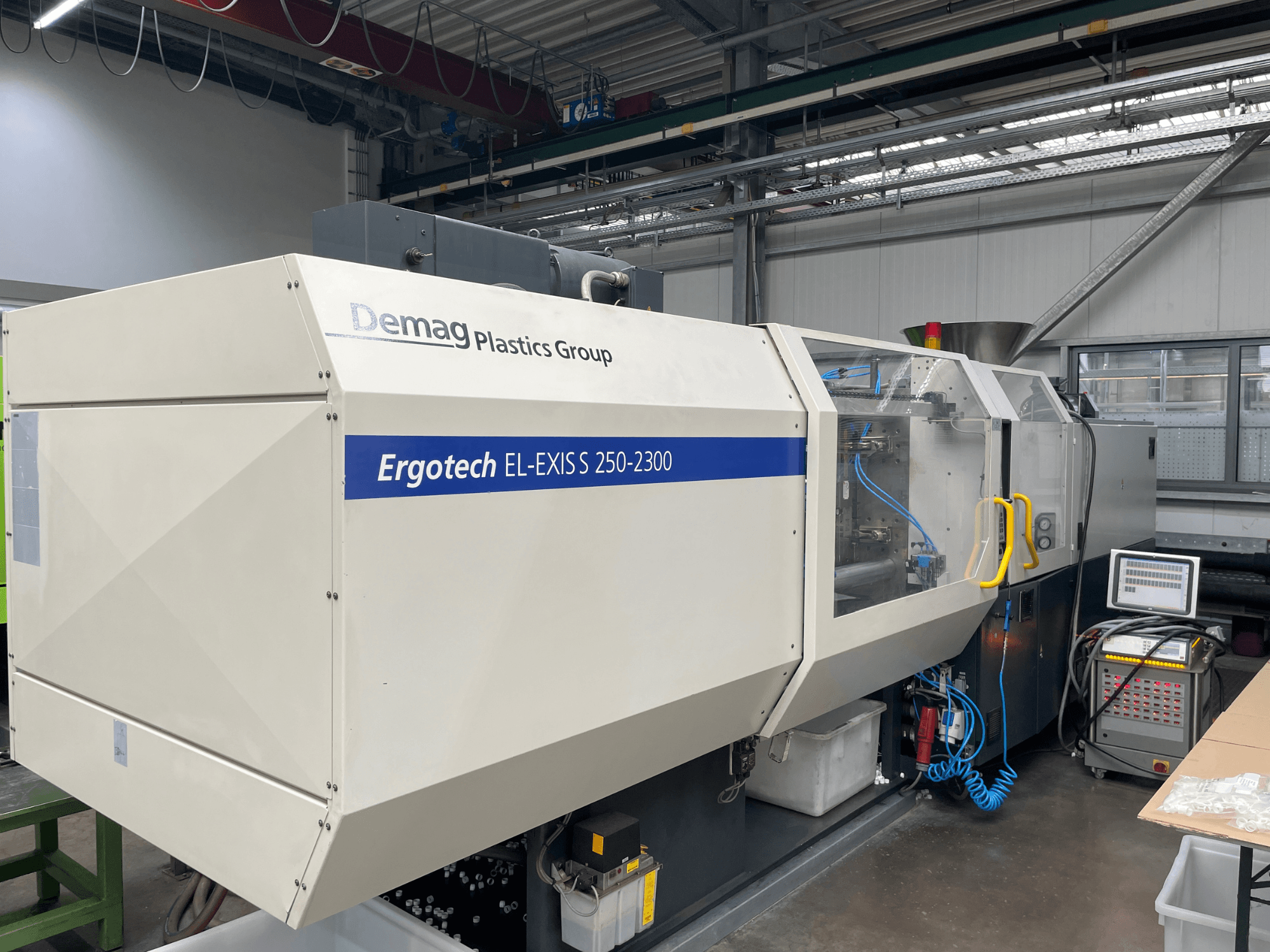 Wtryskarka Demag Ergotech EL-EXIS S 250-2300, widok z boku, panel sterowania i system podawania.