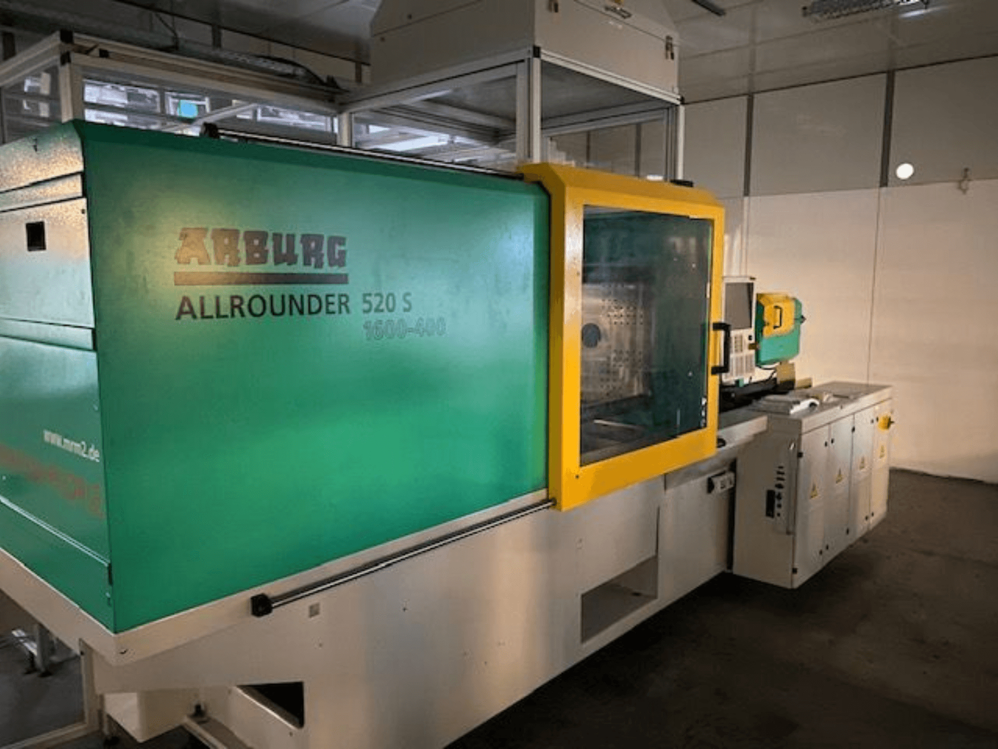 Wtryskarka Arburg Allrounder 520 S, widok z boku, zielono-żółta obudowa, widoczne szczegóły techniczne.