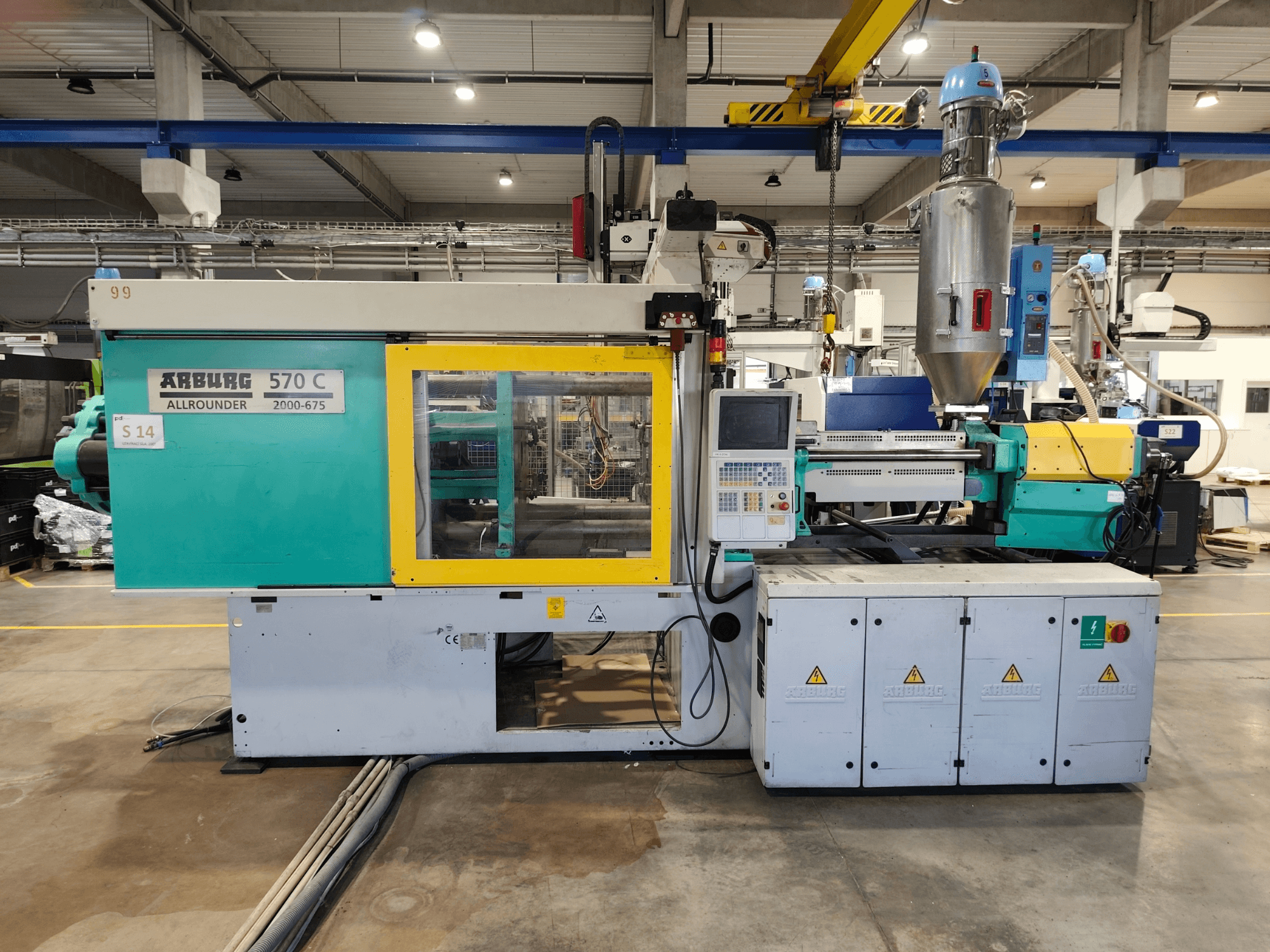 Hydrauliczna wtryskarka Arburg Allrounder 570 C 2000-675, widok z przodu, z panelem sterowania i zbiornikiem na surowiec.