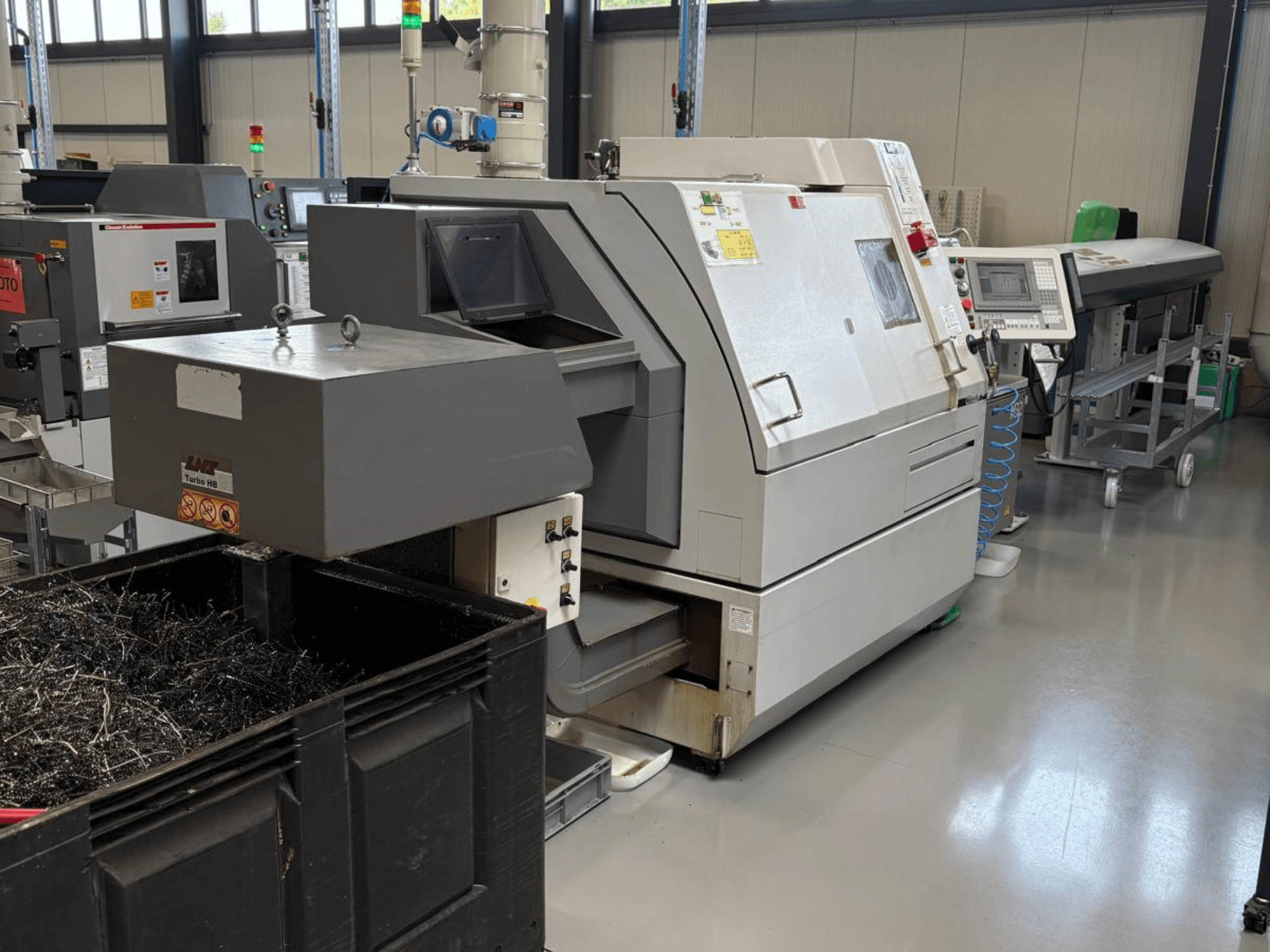 Maszyna przemysłowa LTA Turbo H8, widok z boku, z dużym pojemnikiem na wióry metalowe i panelem sterowania w warunkach fabrycznych.