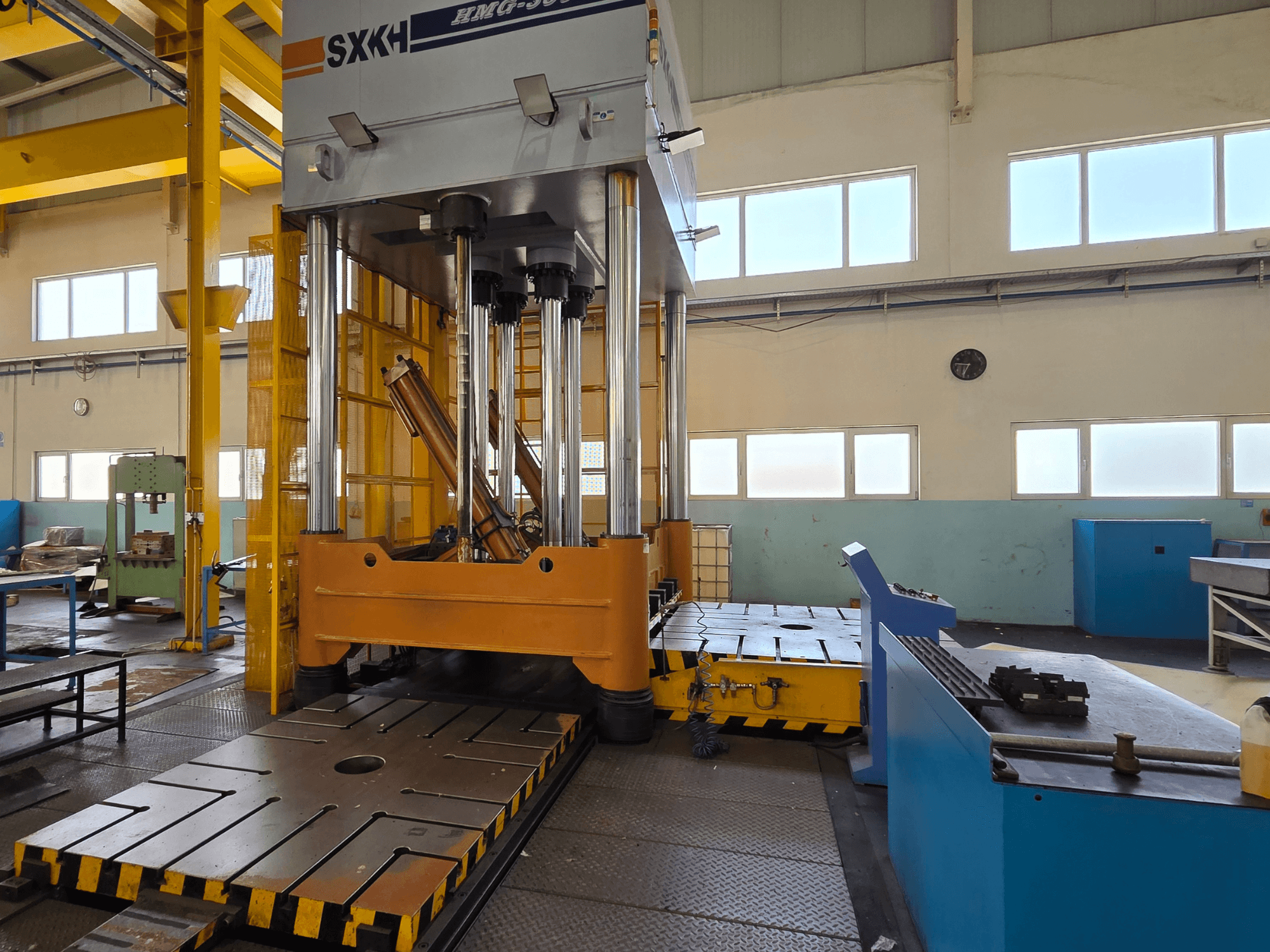 Prasa hydrauliczna SXKH HMG-300JM widok z przodu, wyposażona w duże cylindry dociskowe i solidną podstawę w warunkach fabrycznych.