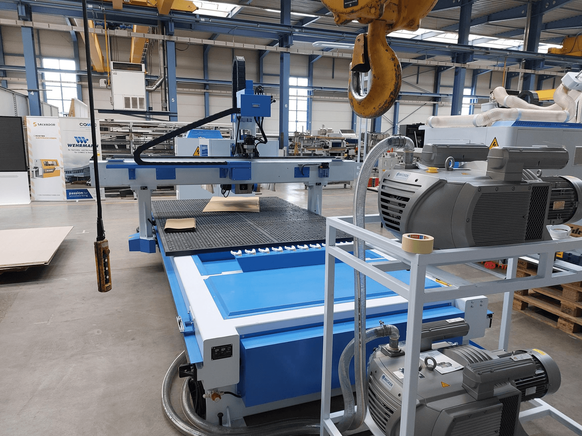 Centrum obróbki drewna CNC QUICK CNC UA 481, widok z przodu przedstawiający panel sterowania, silniki oraz powierzchnię roboczą z umieszczonym na niej kawałkiem drewna.