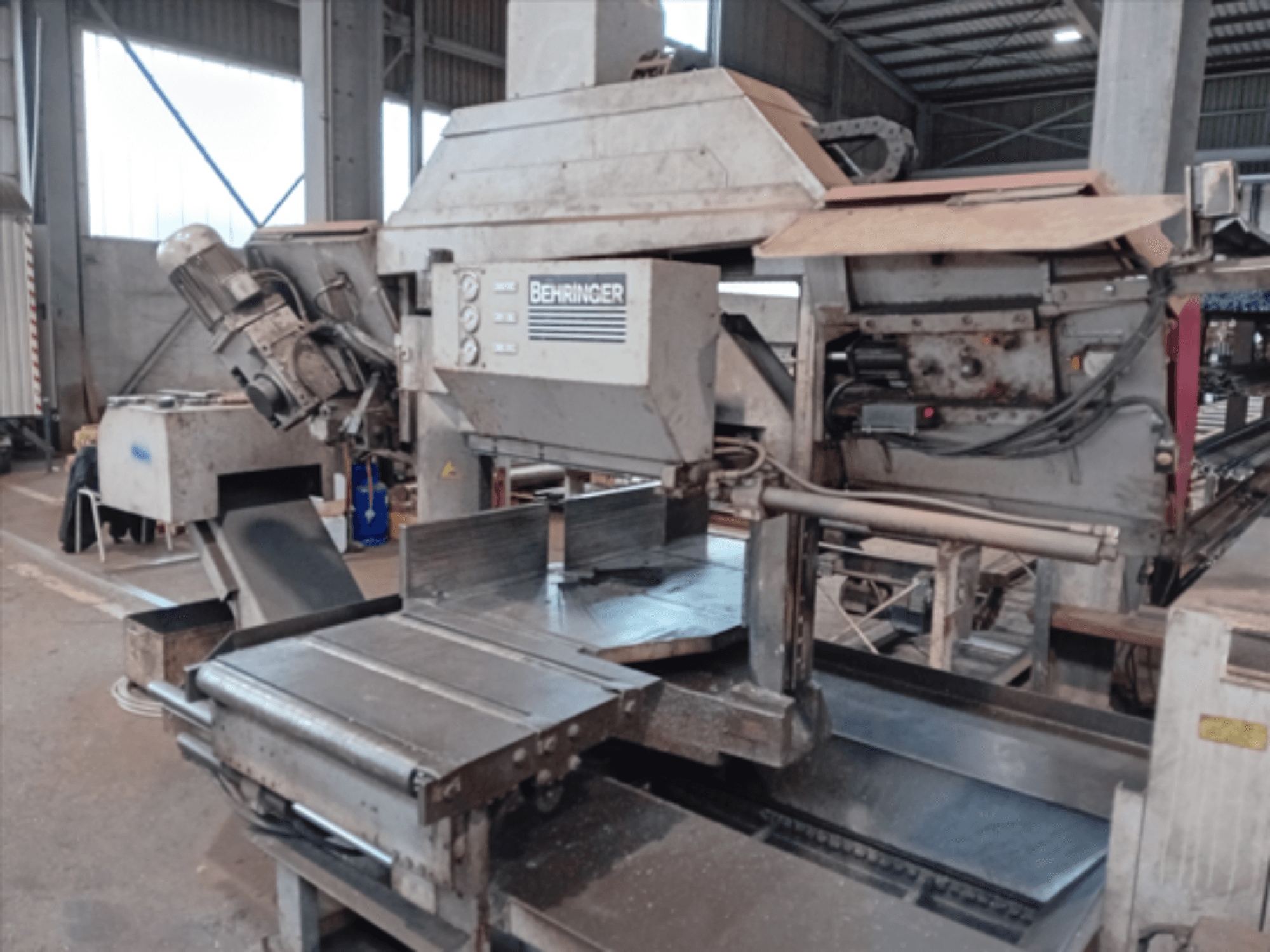 Piła taśmowa Behringer, widok z przodu, wyposażona w duży brzeszczot, silnik i regulowany stół, idealna do cięcia metalu w warsztacie.