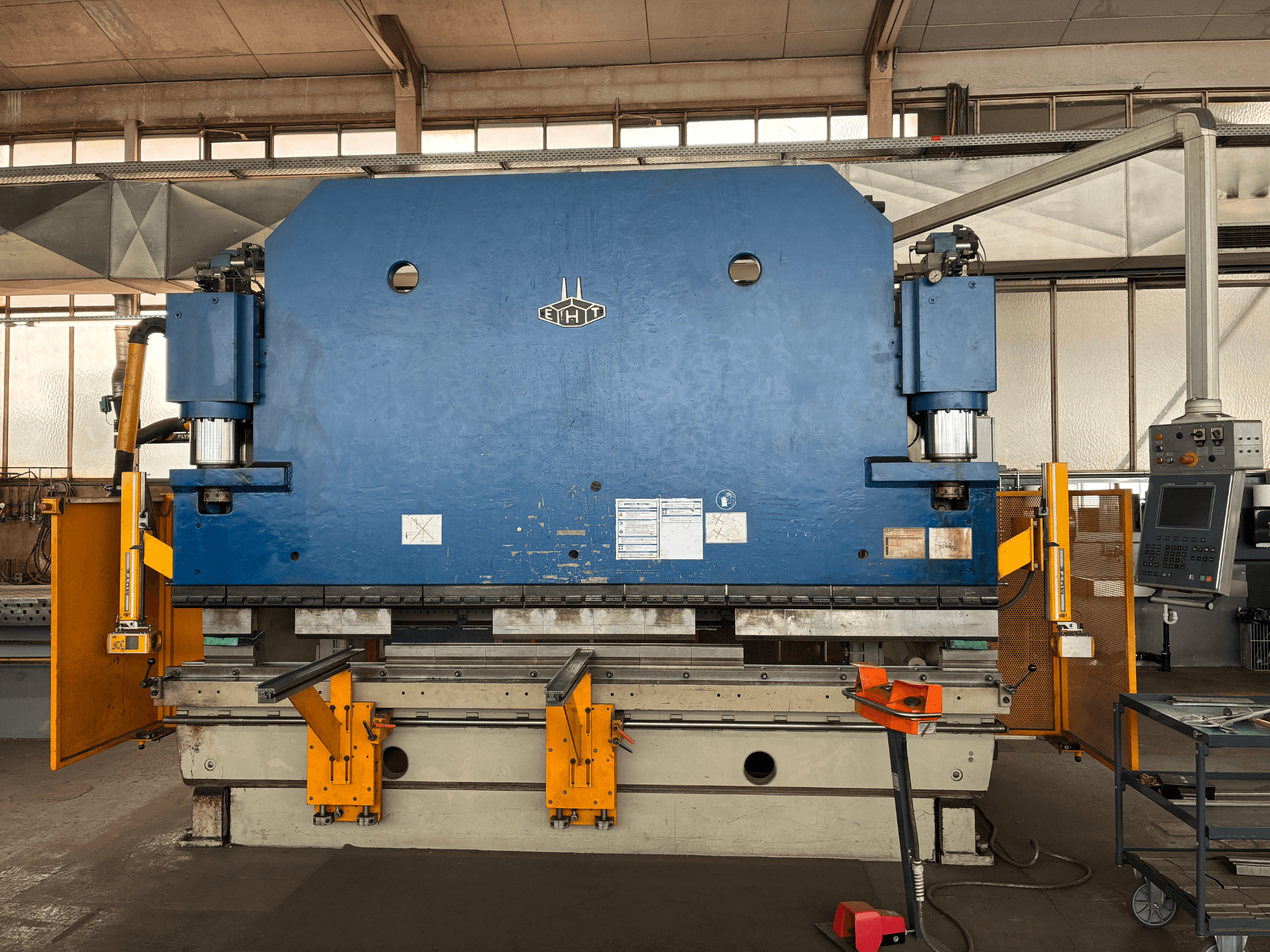Pionowe centrum obróbcze Bridgeport VMC 1000 22, widok z przodu przedstawiający niebieską obudowę, panel sterowania i komponenty operacyjne.