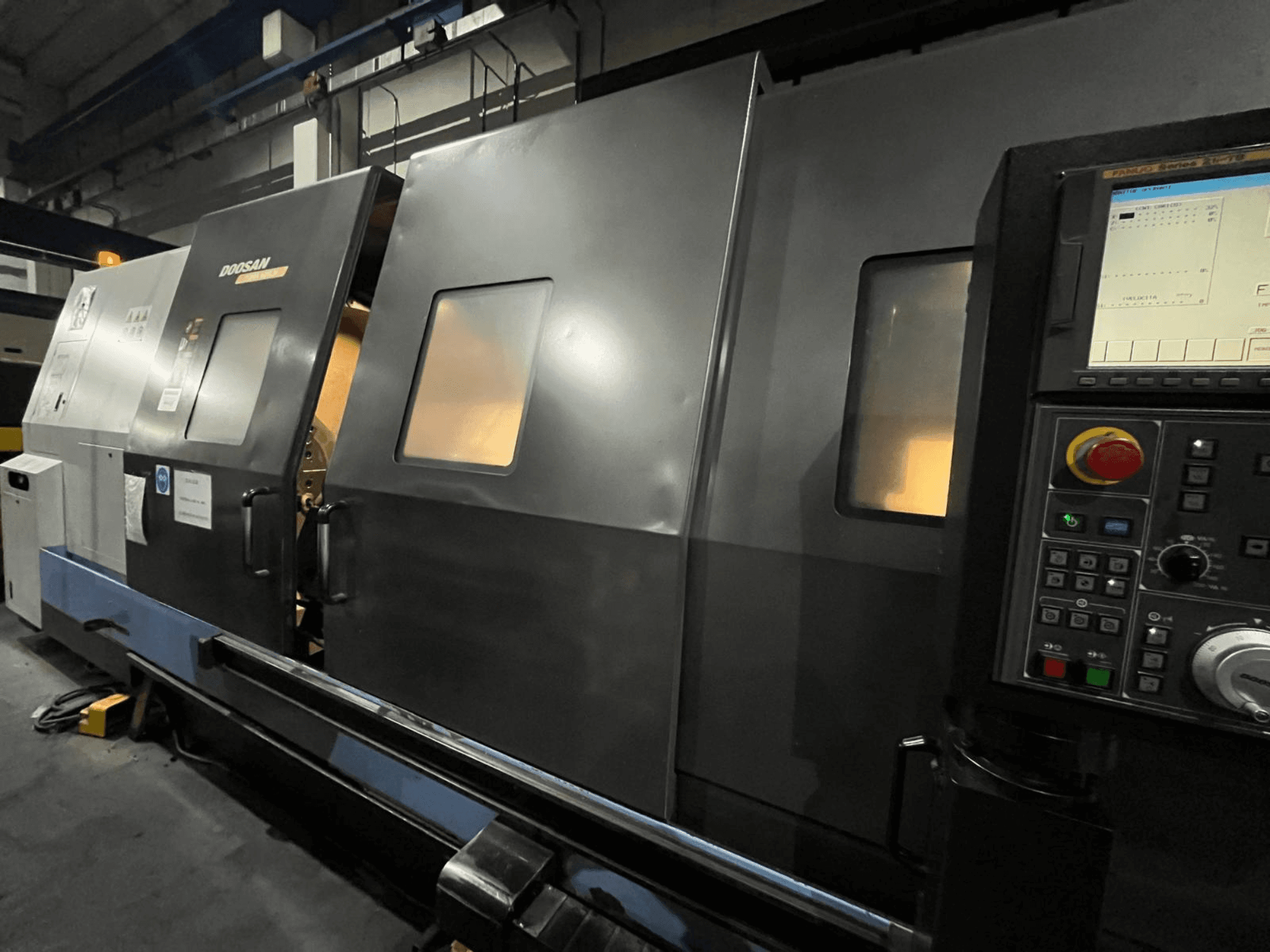 Tokarka CNC Doosan w widoku z przodu, z panelem sterowania i interfejsem operatora z widocznym wyświetlaczem cyfrowym i przyciskami.