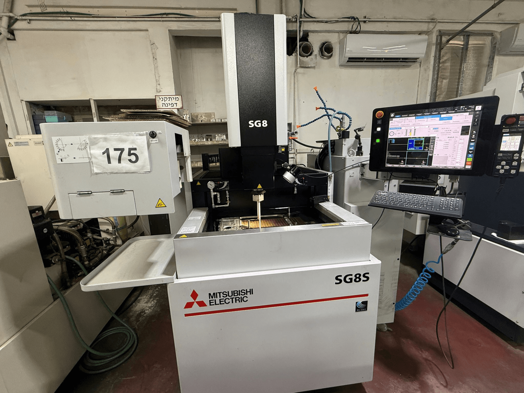 Elektrodrążarka wgłębna Mitsubishi SG8S, widok z przodu z widocznym monitorem i panelem sterowania; obszar roboczy pokazuje konfigurację narzędzia.