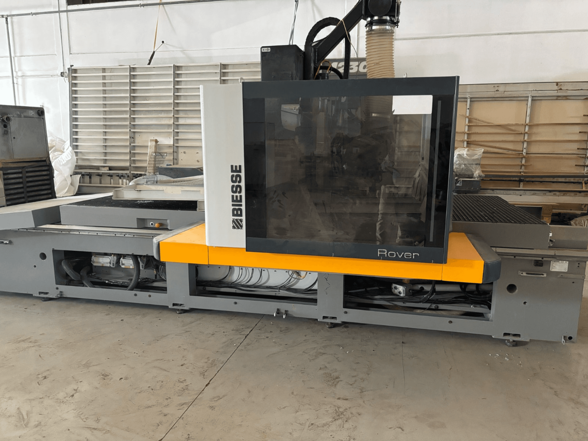 Centrum obróbcze CNC Biesse Rover, widok z przodu, posiada duży panel sterowania, żółte akcenty i odsłonięte komponenty mechaniczne.