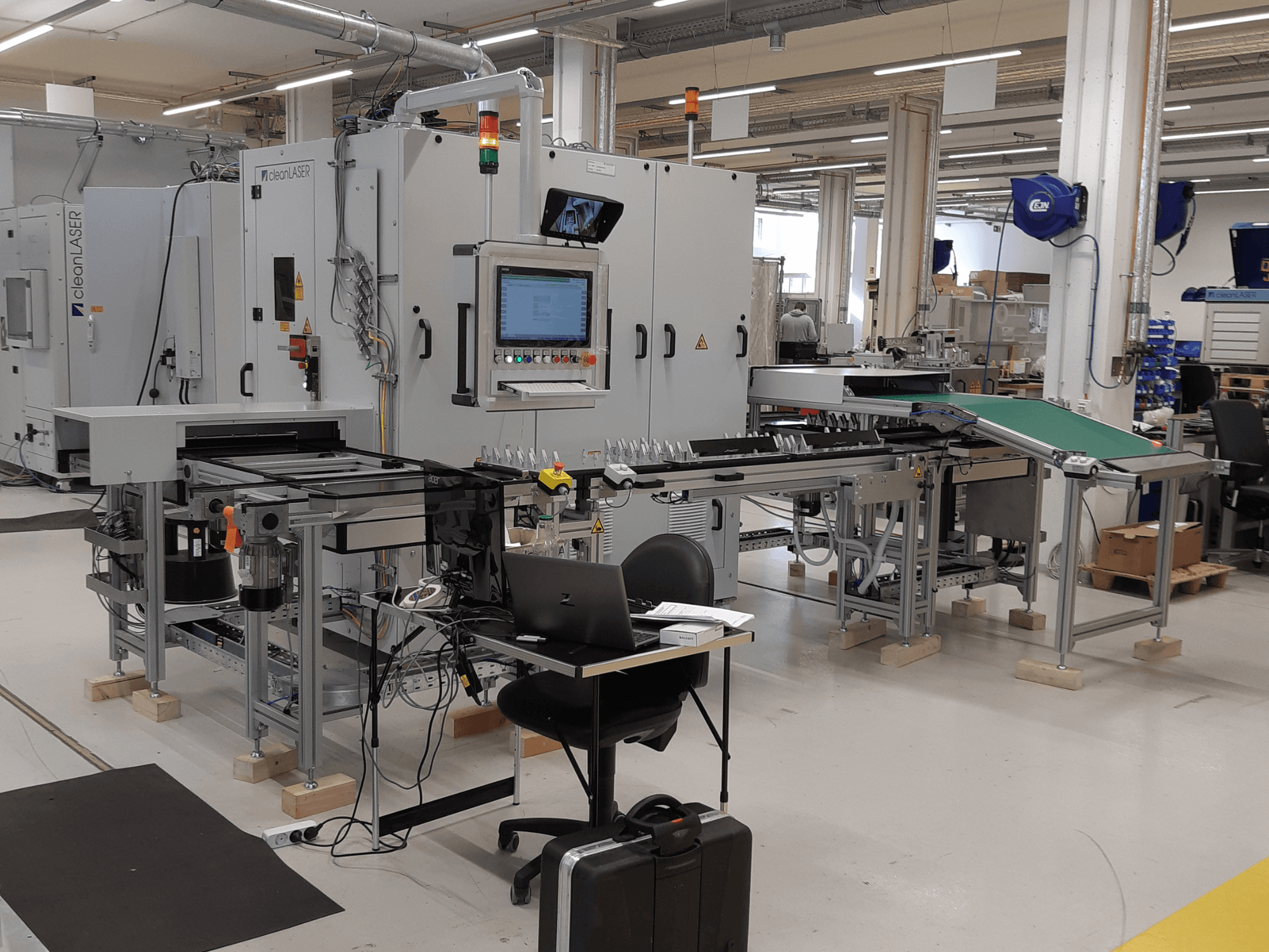 Obrabiarka CLEAN LASER model CELL 3220 – widok z przodu przedstawiający panel sterowania, przenośnik oraz układ obszaru roboczego w środowisku fabrycznym.