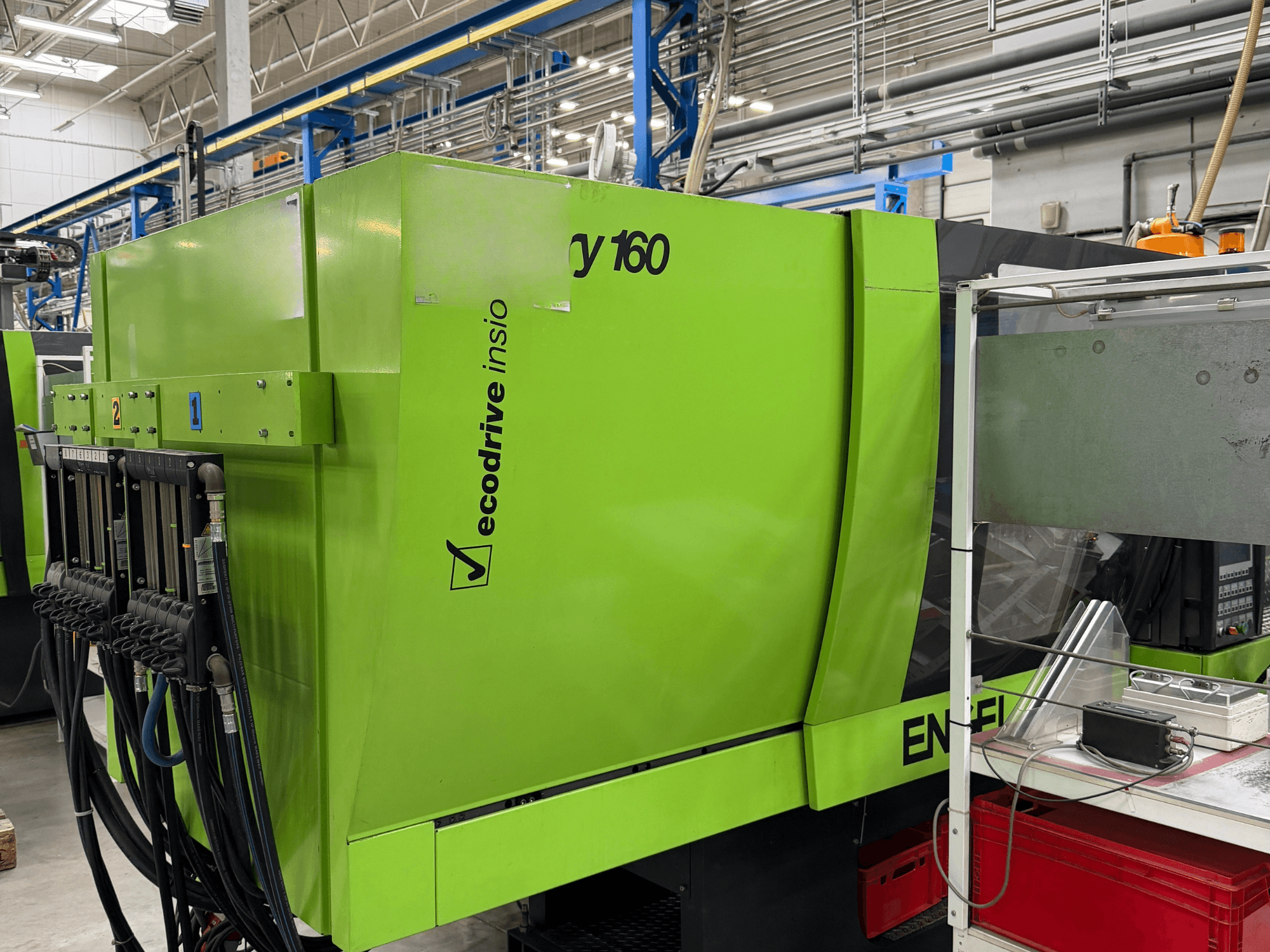 Hydrauliczna wtryskarka Engel Victory 500/160 w kolorze zielonym, widok z boku przedstawiający panel sterowania oraz funkcję Ecodrive.