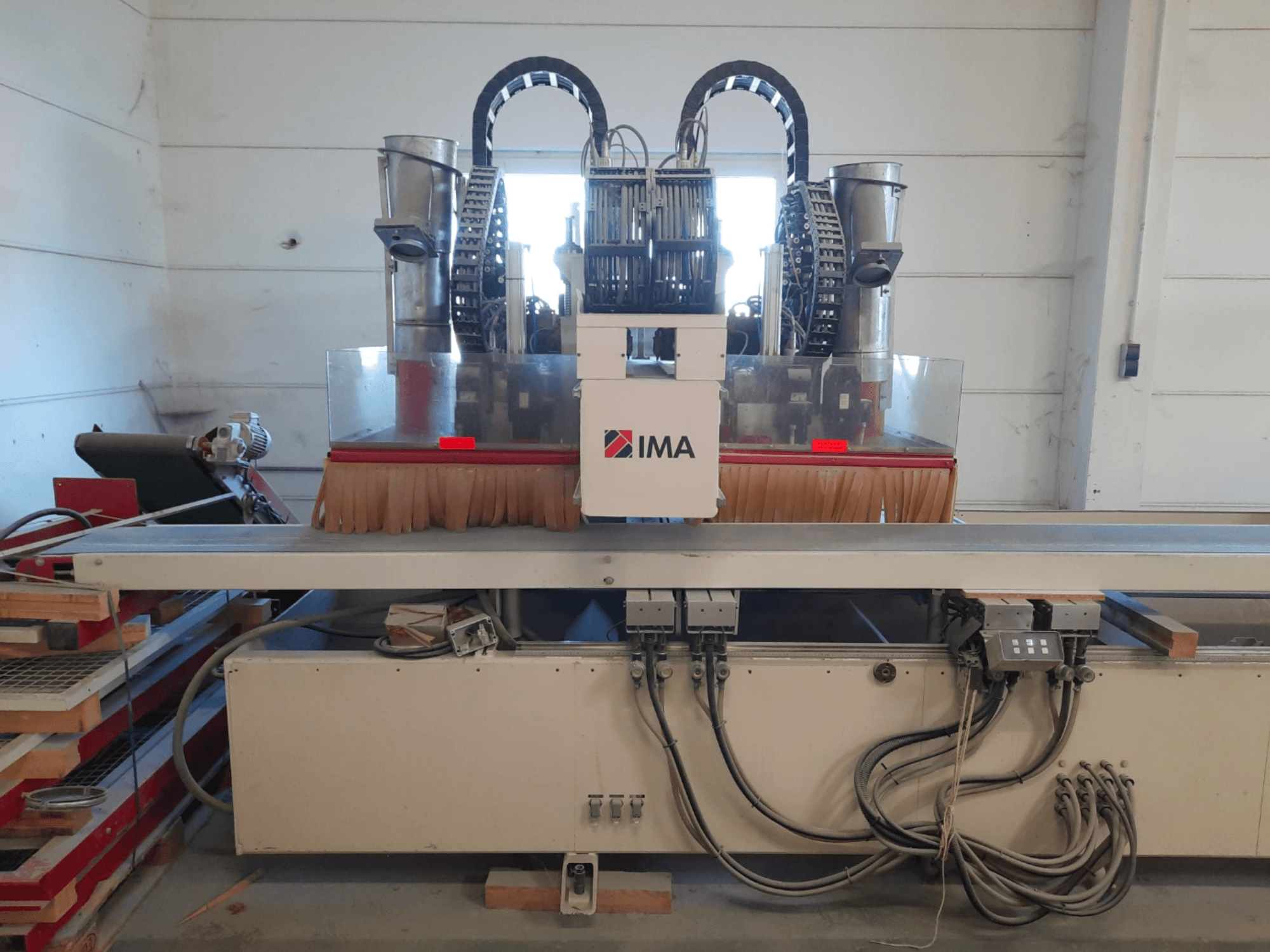 Centrum obróbki drewna CNC IMA BIMA 610 V widziane od przodu, z widocznymi szczotkami, elementami sterującymi i stołem roboczym.