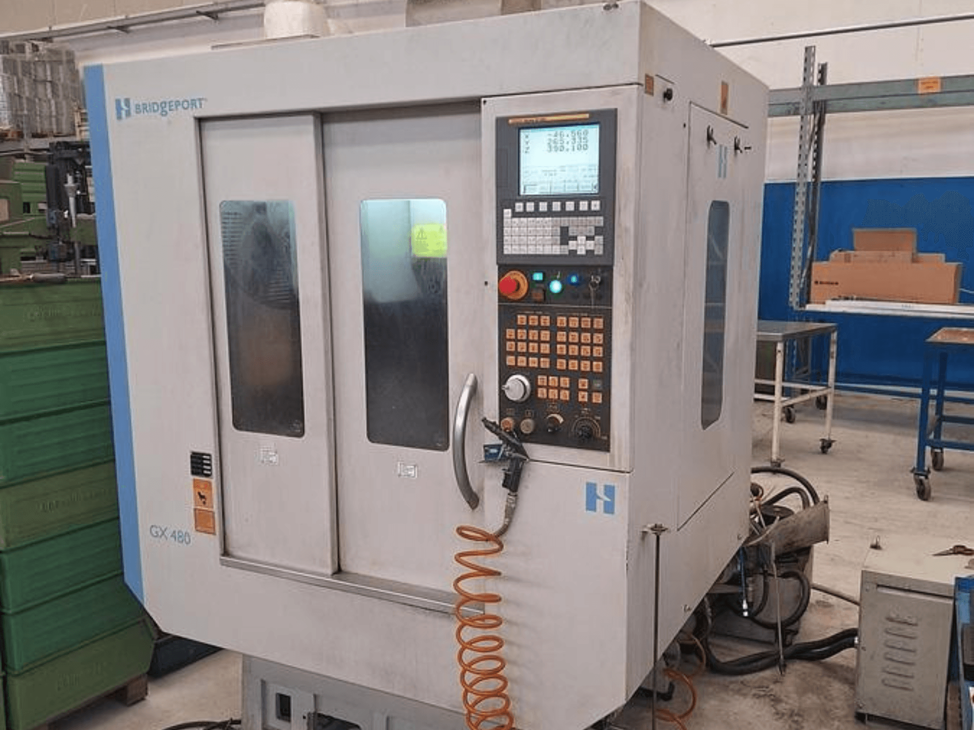 Pionowe centrum obróbcze Bridgeport GX 480 w widoku z przodu, z panelem sterowania, podwójnymi szklanymi drzwiami i elastycznym wężem.