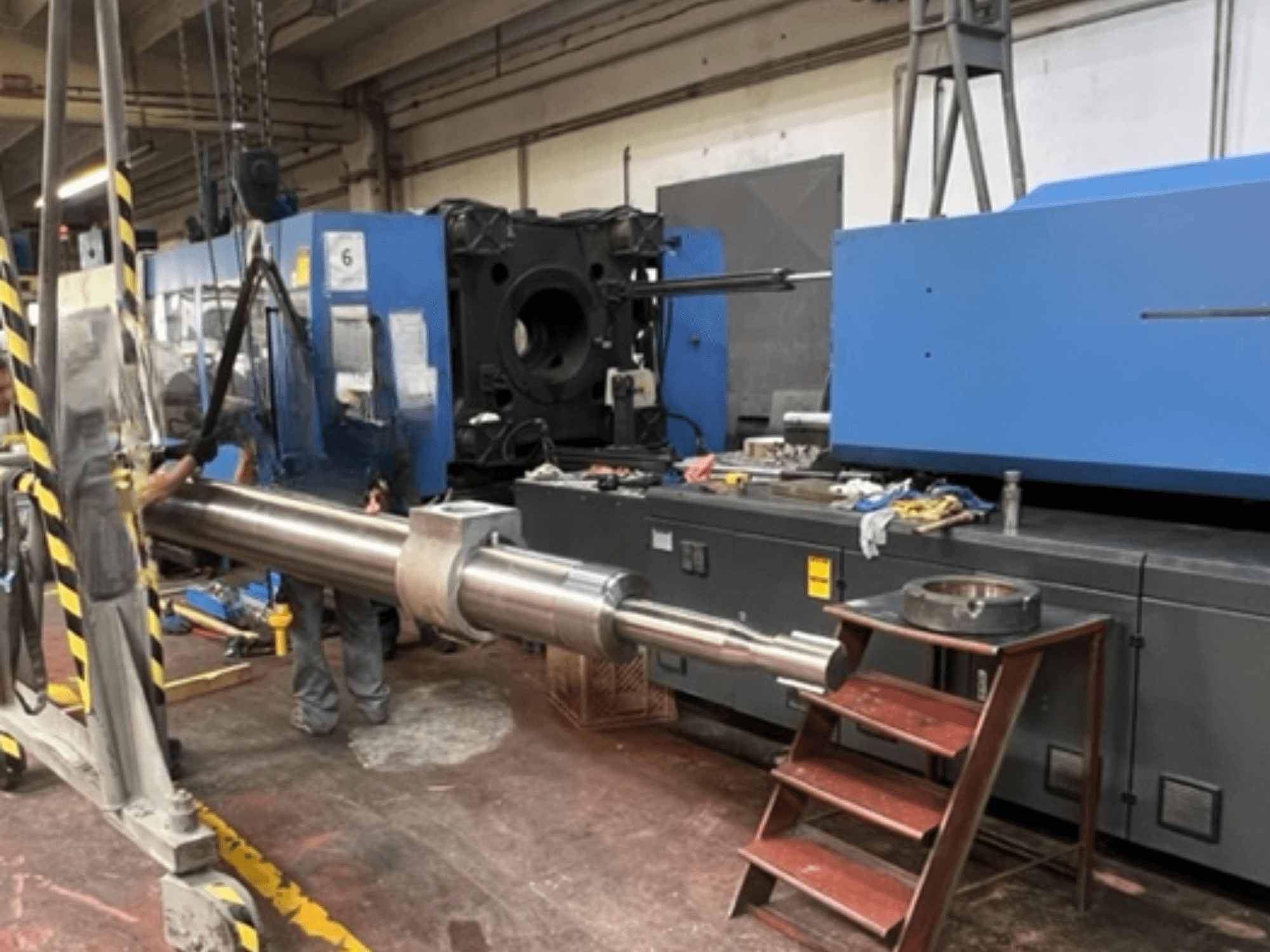 Hydrauliczna wtryskarka HAITIAN SA8000, przedstawiona w widoku z boku podczas podnoszenia dużego tłoka hydraulicznego.