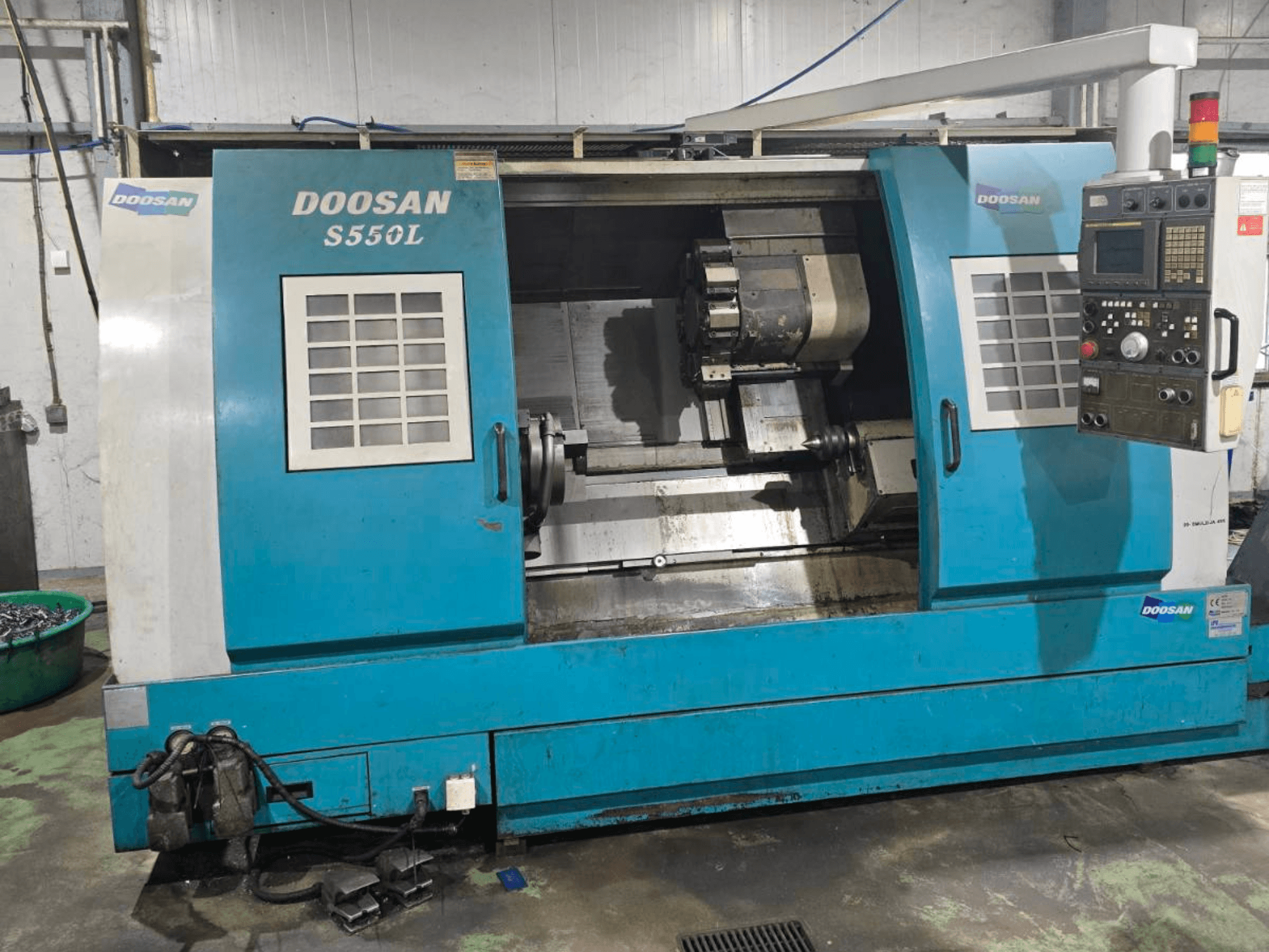 Tokarka pozioma DOOSAN S550L w widoku z boku, z panelem sterowania i łożem tokarskim, idealna do precyzyjnej obróbki.