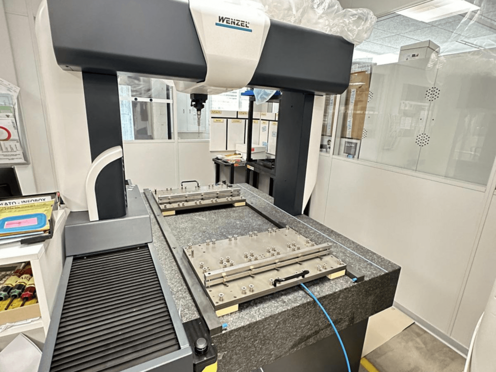 Maszyna CMM Wenzel LH 65 w warunkach laboratoryjnych, wyposażona w granitową podstawę z regulowaną platformą pomiarową i ramieniem górnym.