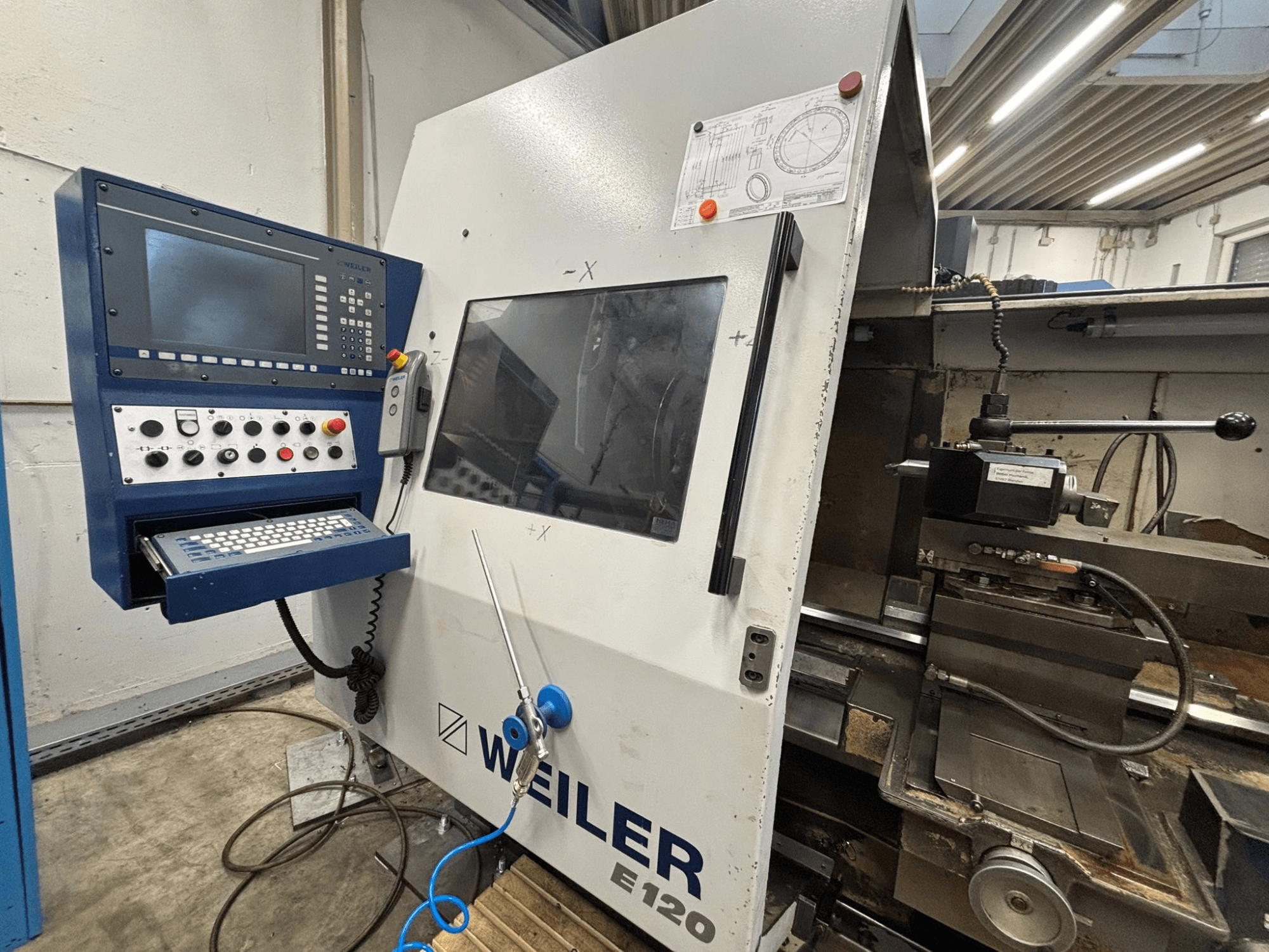 Panel sterowania i interfejs maszyny CNC Weiler E-120, widok z przodu z widocznymi przyciskami, ekranem wyświetlacza i elementami obsługi.