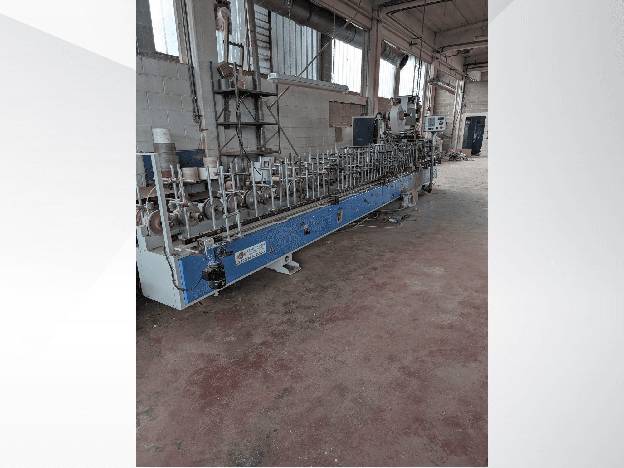 Widok z przodu maszyny PUR-33-L do drewna, z wieloma wrzecionami i eleganckim niebieskim designem w otoczeniu przemysłowym.