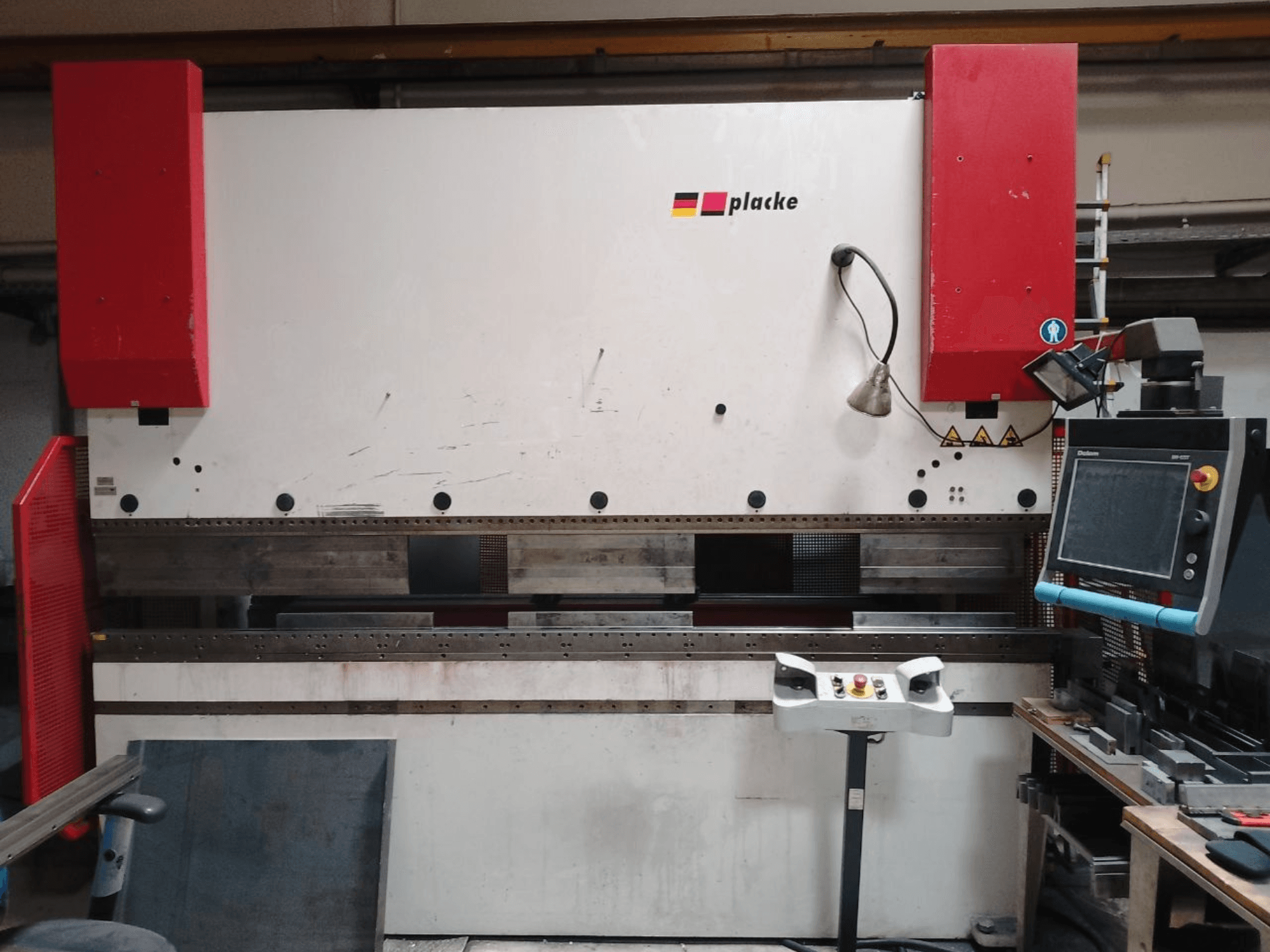 Prasa krawędziowa PLACKE QPB-4 150/3100, widok z przodu przedstawiający panel sterowania, czerwone ramiona oraz obszar gięcia metalu.