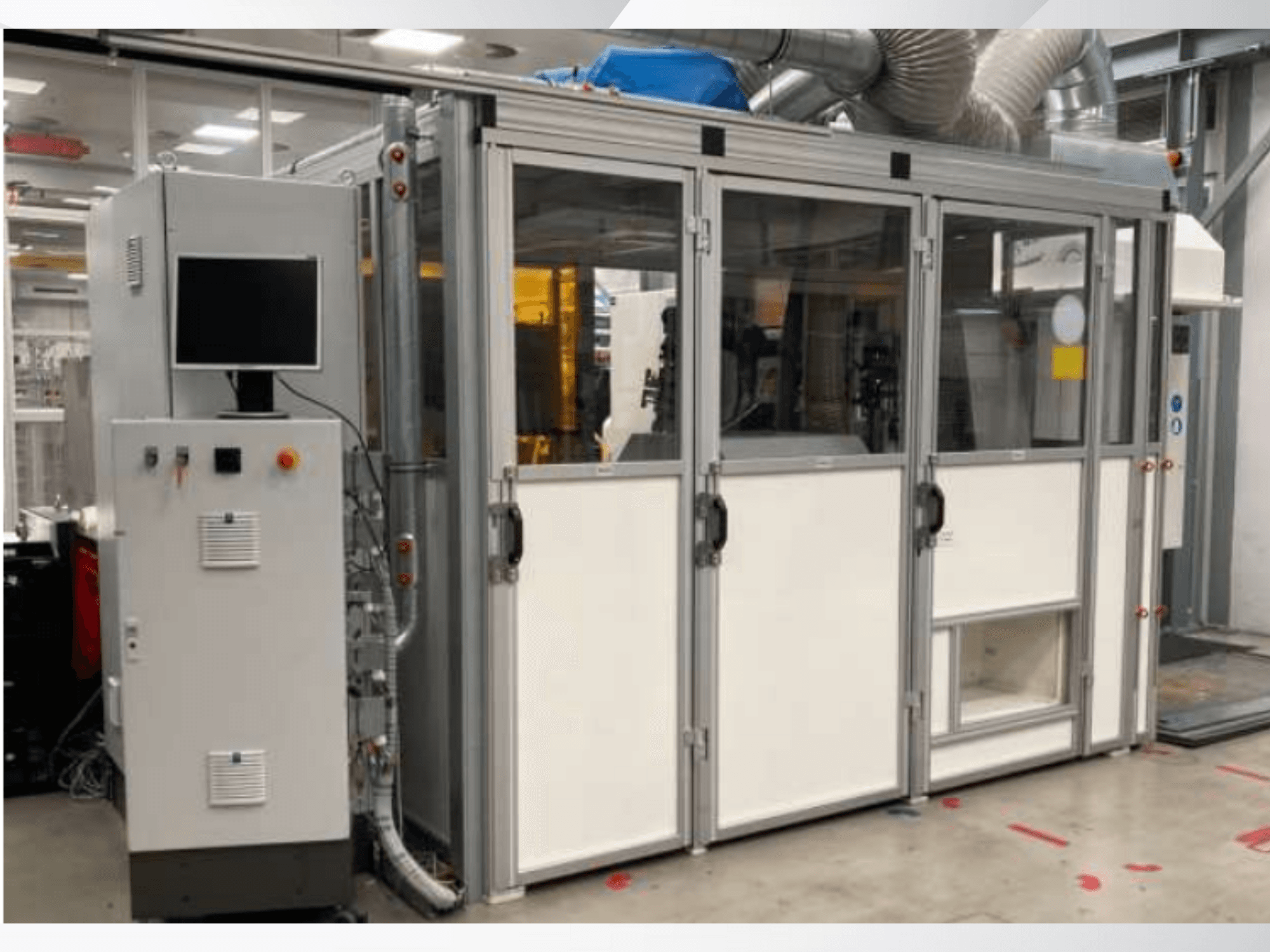 Maszyna przemysłowa z panelem sterowania, widok z przodu; posiada szklane drzwi, kanały wentylacyjne i widoczne okablowanie.
