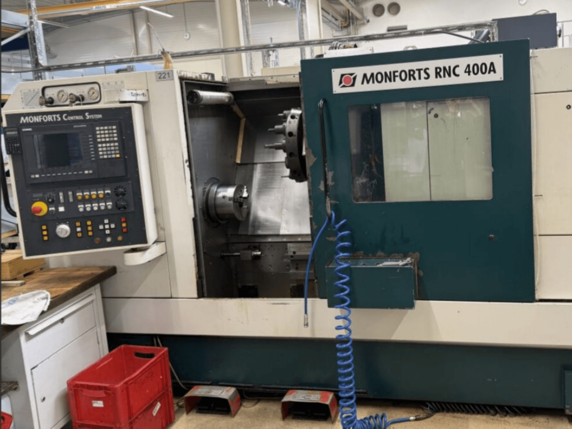 Monforts RNC 400 A tokarka pozioma, widok z przodu, panel sterowania i obszar roboczy z wyróżnionymi funkcjami.