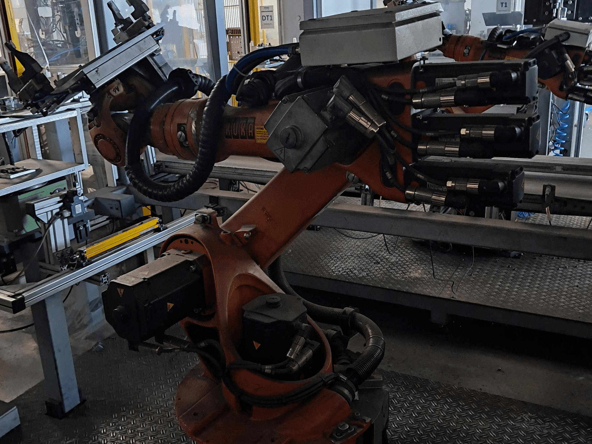 Ramię robota KUKA KR 16-2 ze sterownikiem KRC 4 – widok z boku przedstawiający przeguby, kable oraz mocowanie narzędzia.