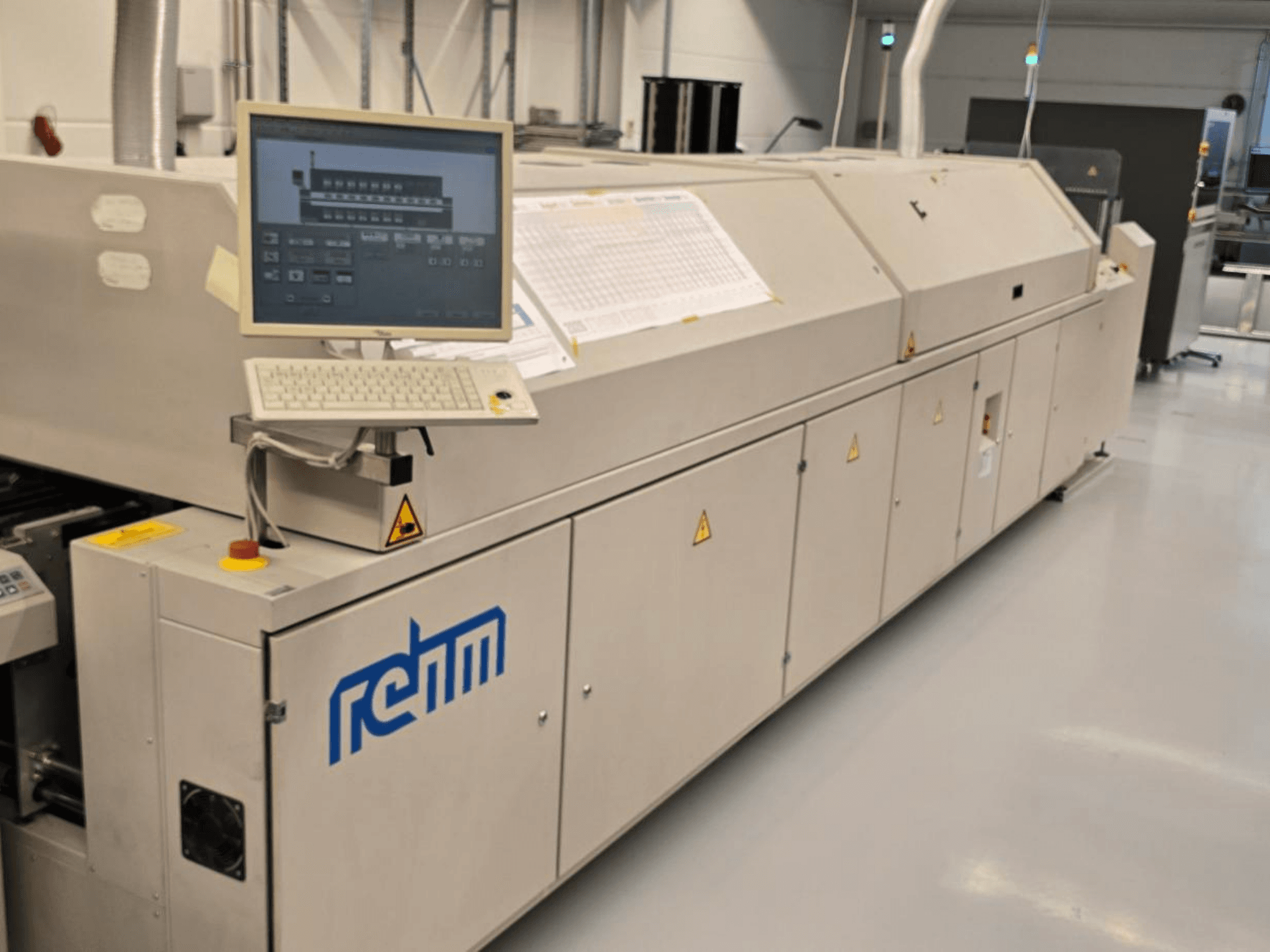Urządzenie automatyzacyjne REHM VXS nitro 2450, widok z przodu; w zestawie znajduje się monitor, klawiatura oraz panel sterowania służący do obsługi urządzenia.