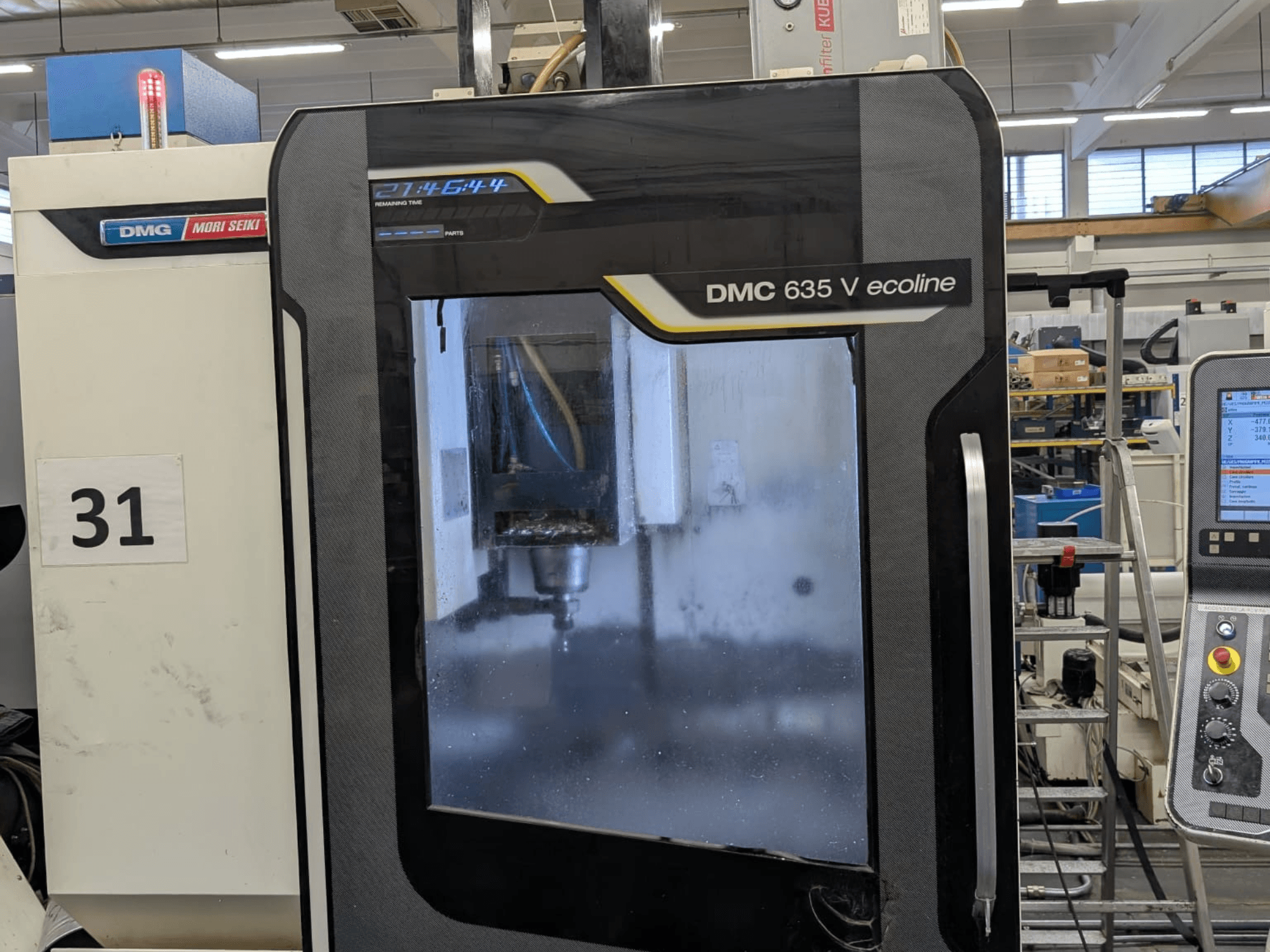 Pionowe centrum obróbcze DMG Mori Seiki DMC 635V ecoline, widok z przodu z panelem sterowania i widocznym obszarem obróbki.