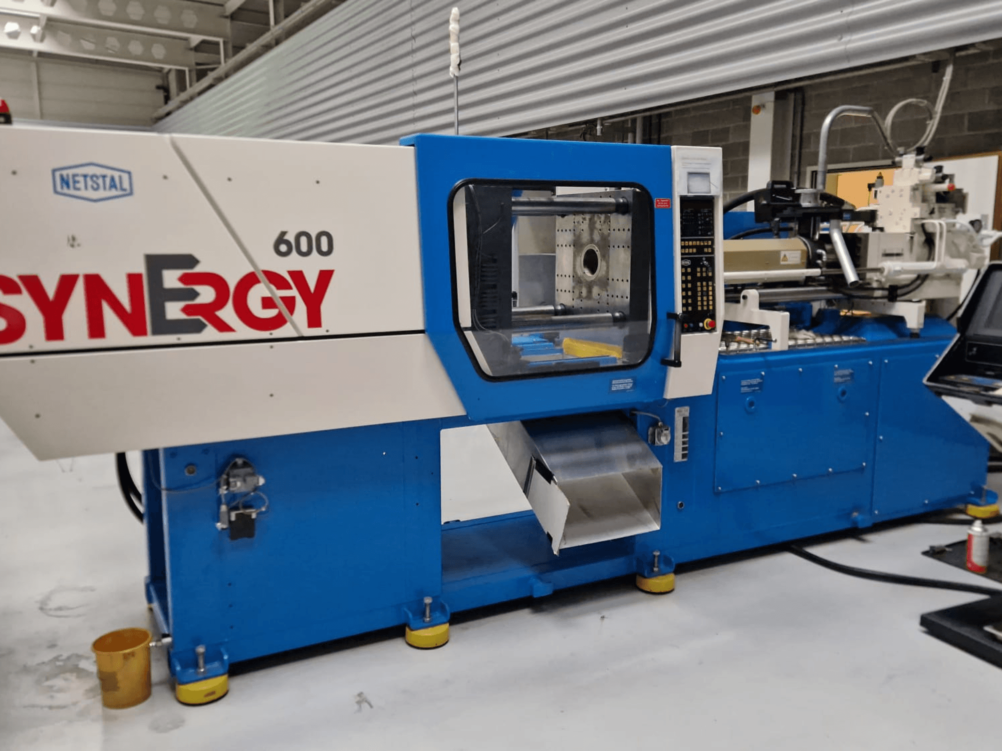 Wtryskarka hydrauliczna Netstal Synergy 600-230, widok z boku pokazujący panel sterowania i obszar wtrysku.