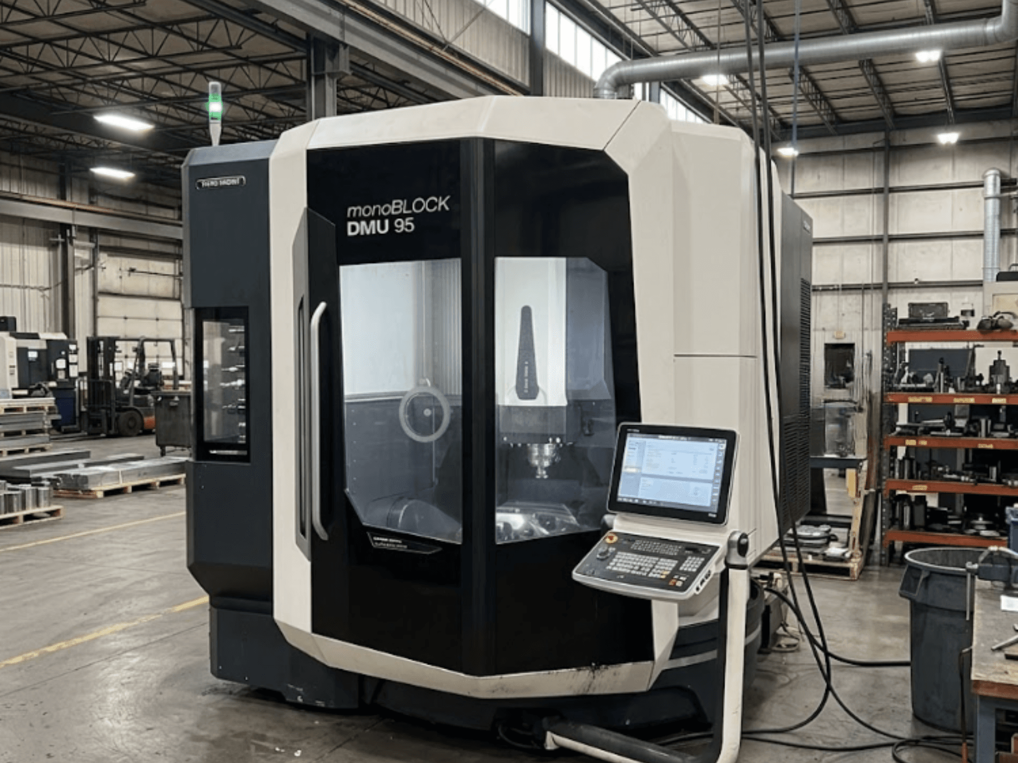 Pionowe centrum obróbcze DMG MORI DMU 95 Monoblock w zakładzie produkcyjnym z widocznym panelem sterowania, widok z przodu.