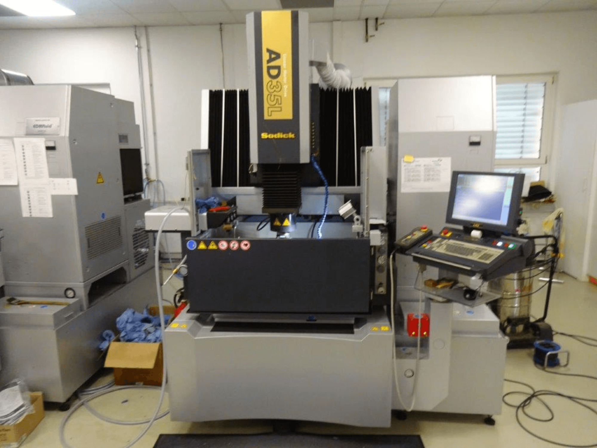 Elektryczna maszyna wyładowcza Sodick AD35L, widok z przodu z widocznym panelem sterowania, układem chłodzenia i obszarem roboczym.