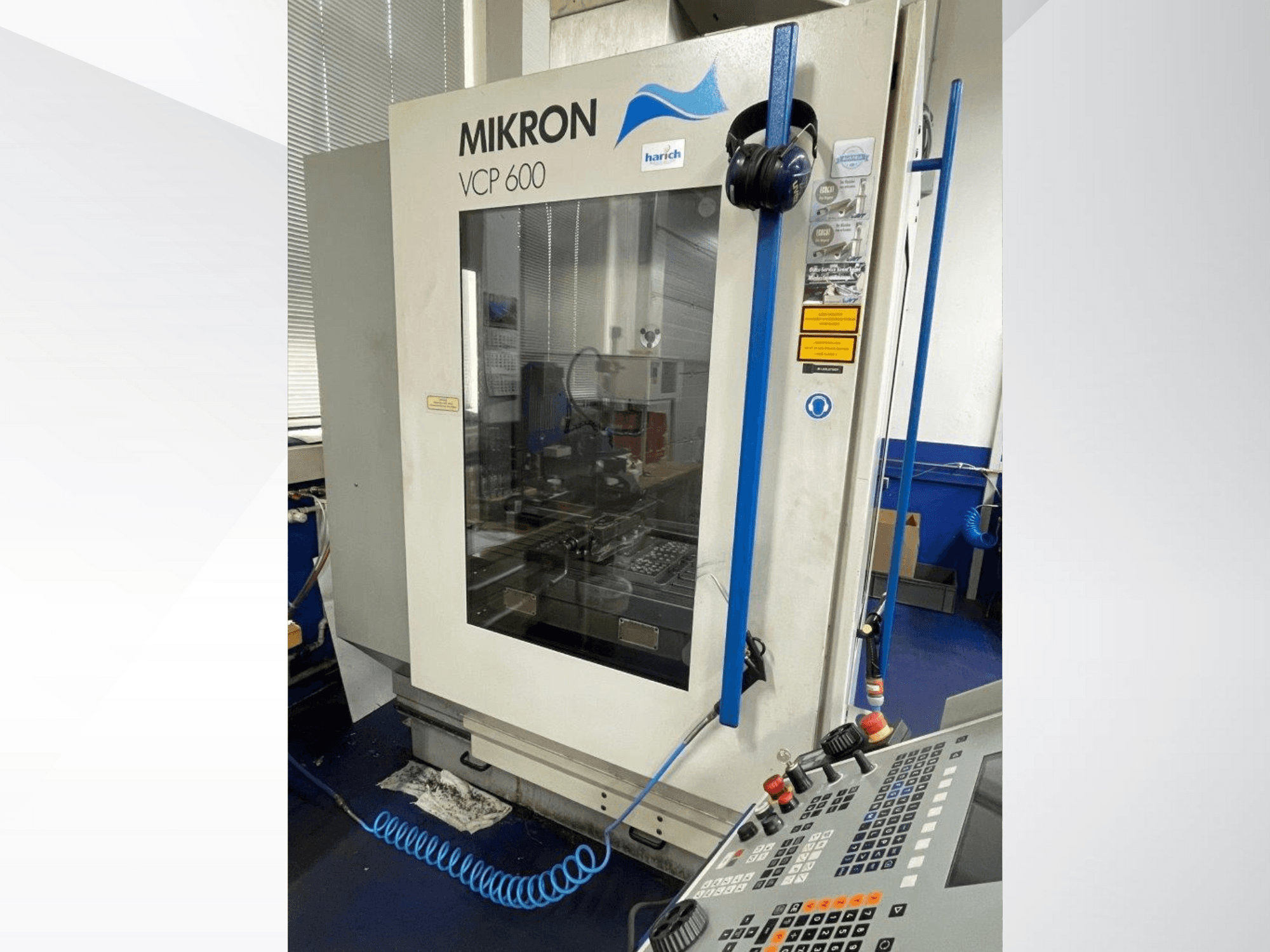 Maszyna CNC Mikron VCP 600, widok z przodu, panel sterowania z przyciskami i widoczny obszar obróbki za szybą.