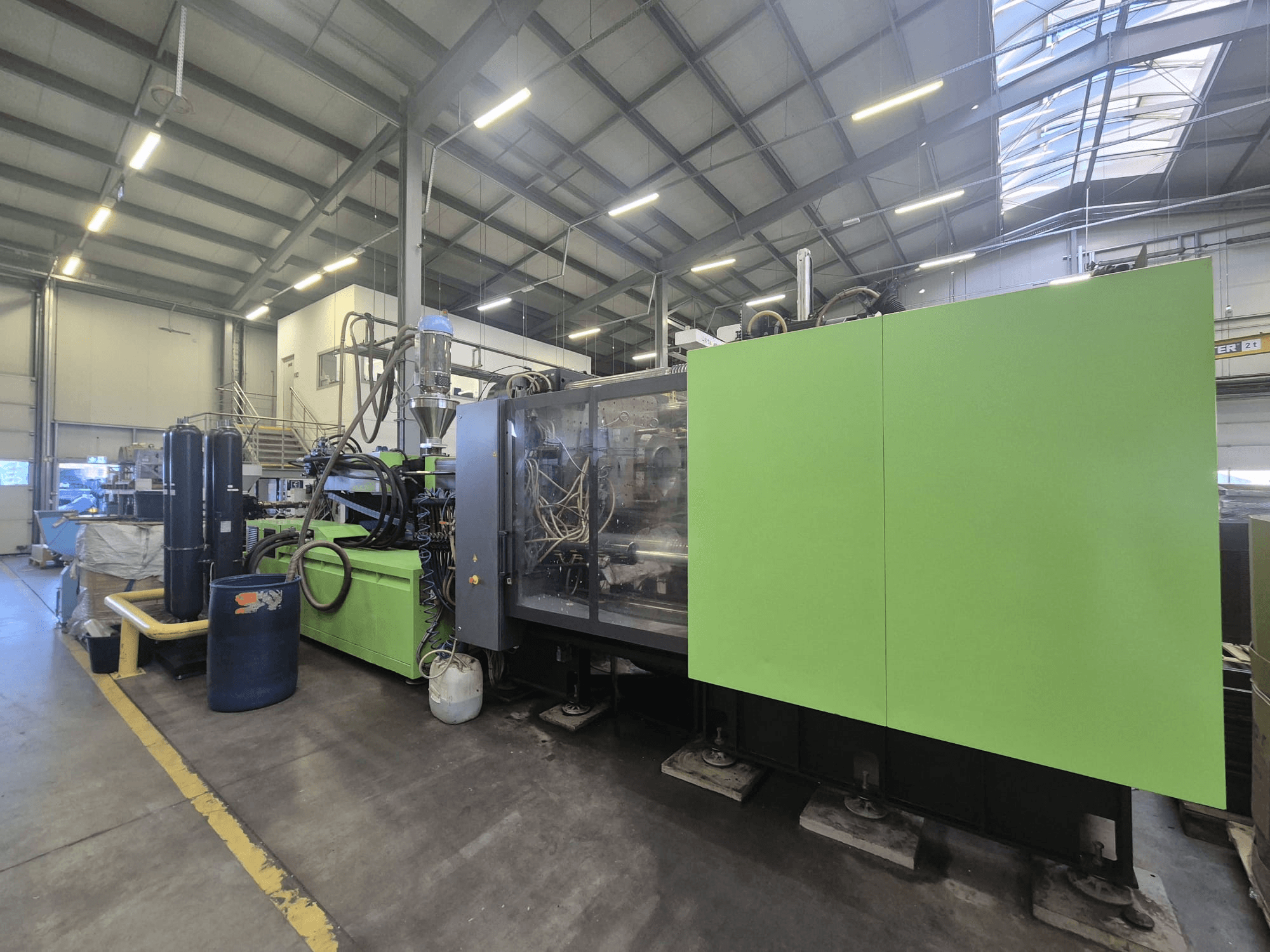 Hydrauliczna wtryskarka Engel duo 5160/700 w warunkach fabrycznych, widziana z boku, prezentująca swoją zieloną obudowę i poszczególne elementy.