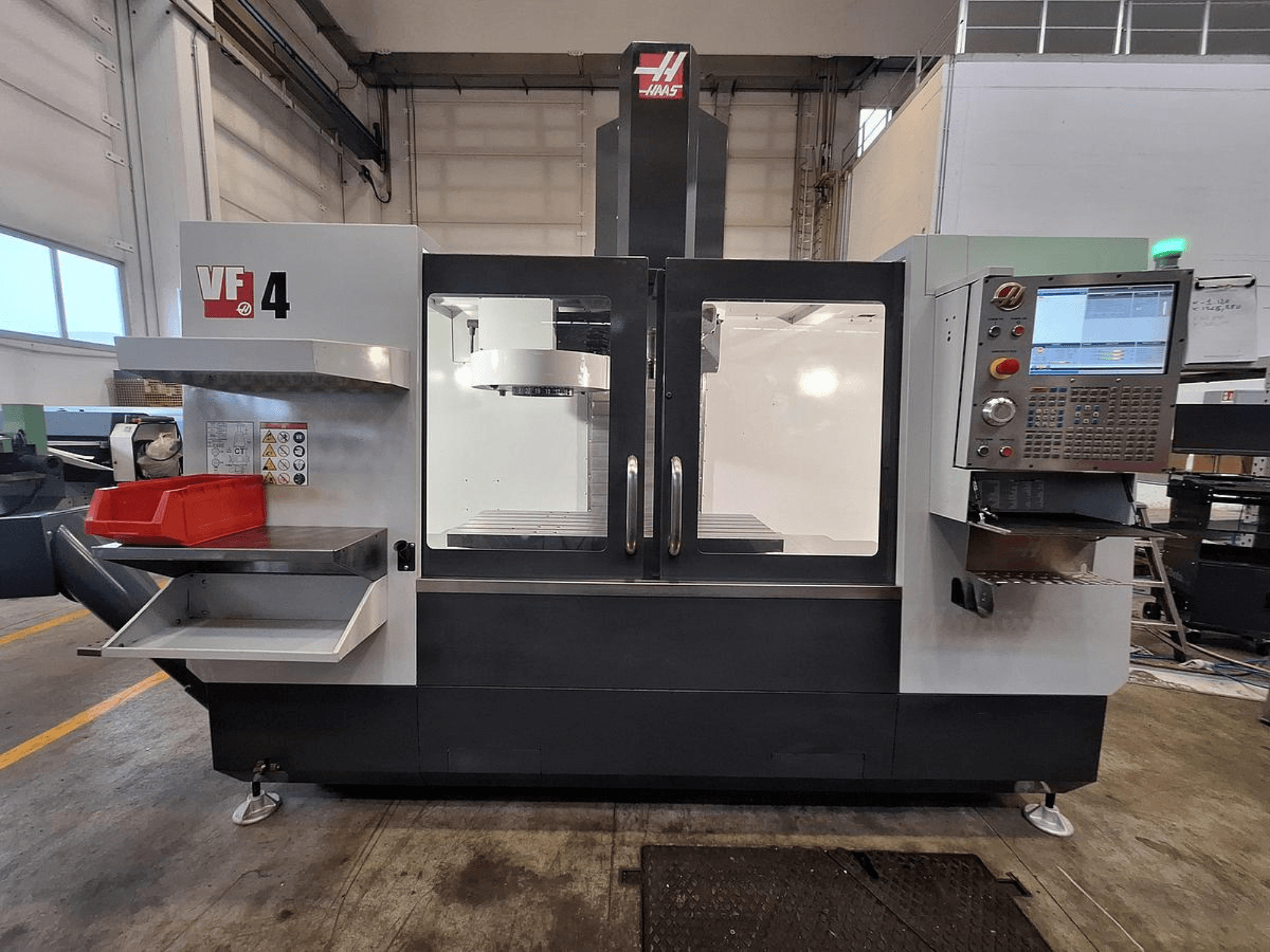 Pionowe centrum obróbcze Haas VF-4, widok z przodu, z panelem sterowania, uchwytem narzędziowym i przestronnym obszarem roboczym.