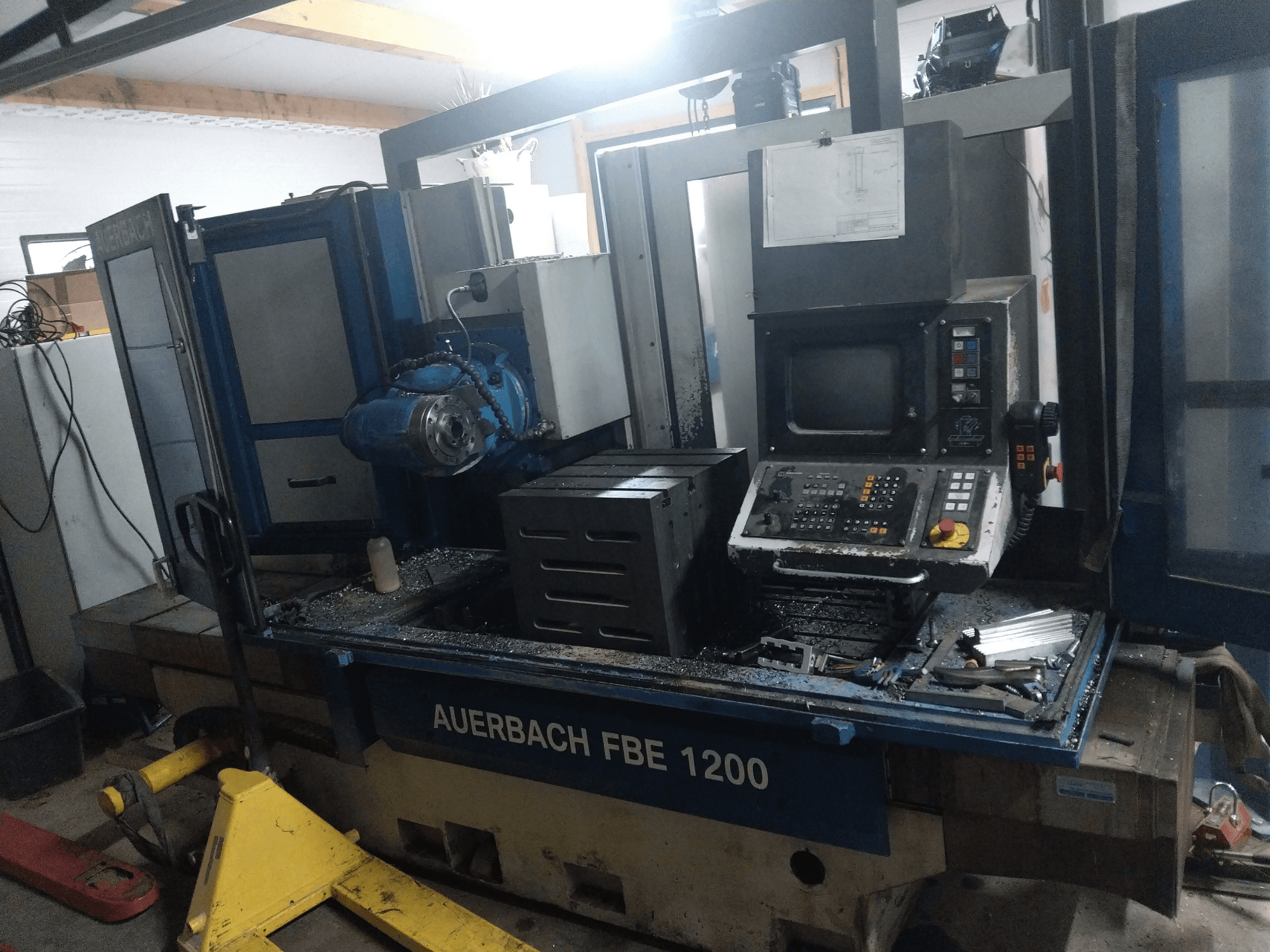Wiertarka do metalu Auerbach FBE 1200, widok z przodu, pokazujący panel sterowania, silnik i metalowe wióry na powierzchni roboczej.