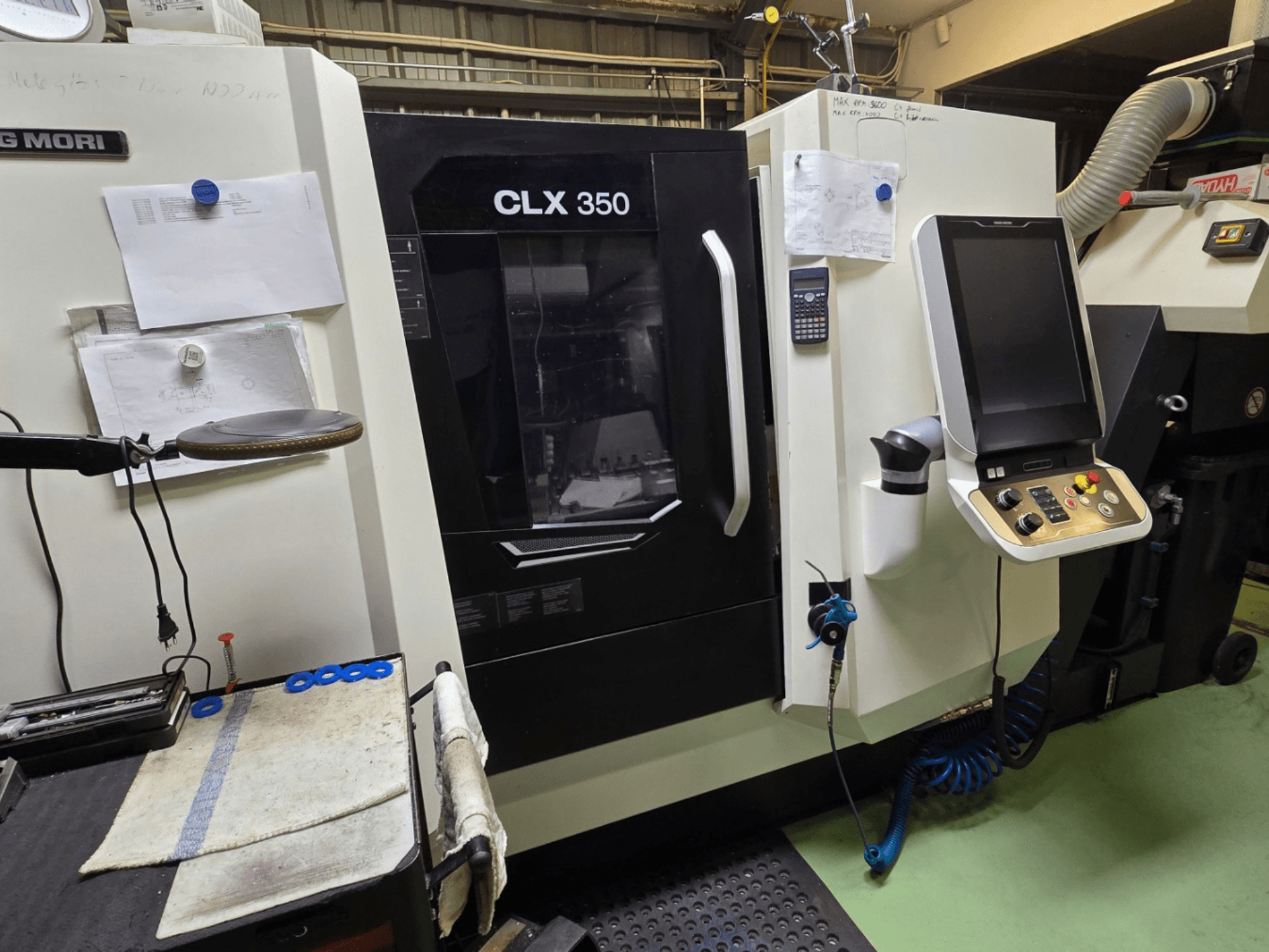 Tokarka CNC DMG MORI CLX 350 w warsztacie; widok z przodu z widocznym panelem sterowania, narzędziami i obszarem roboczym.