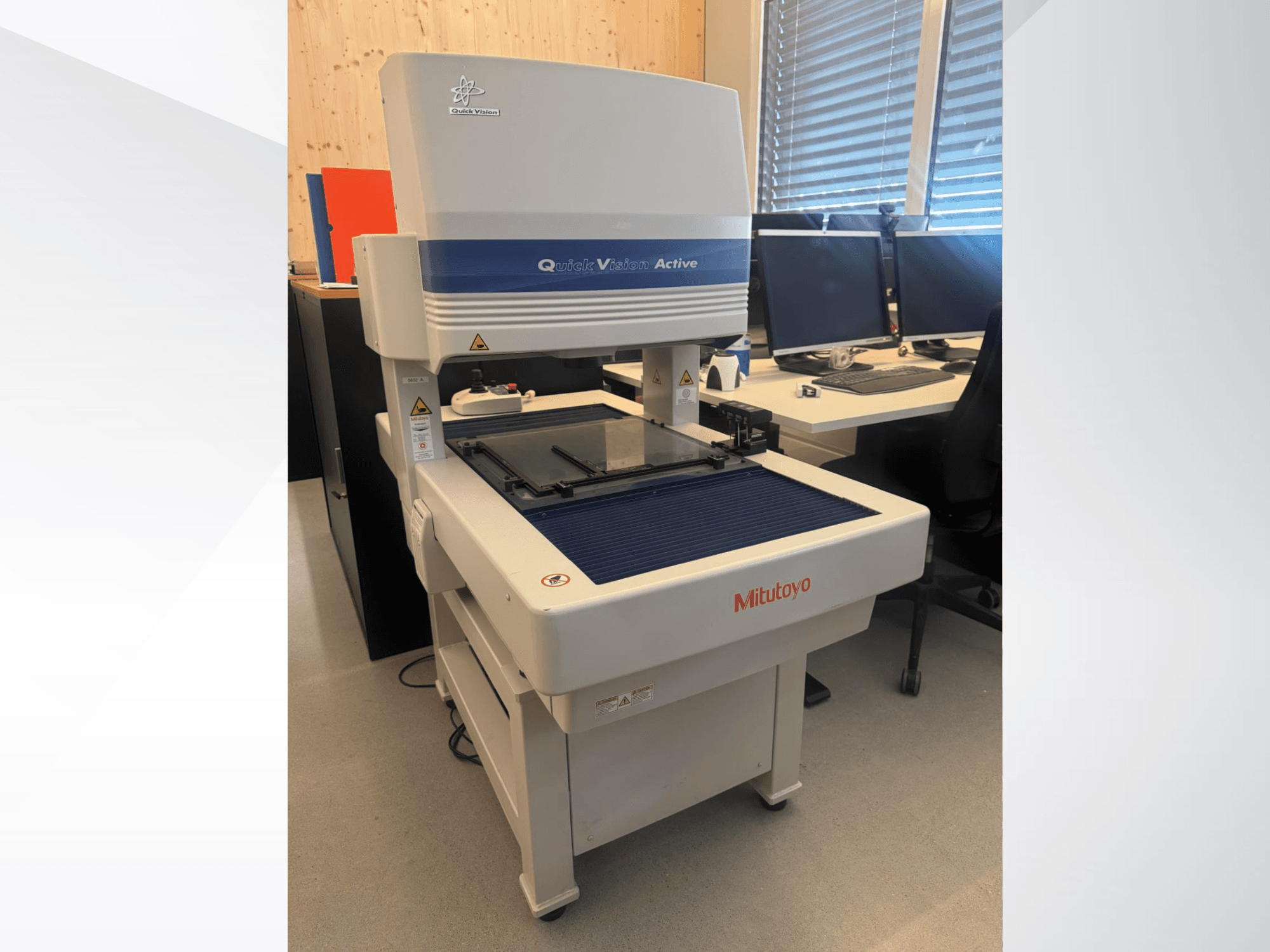 Współrzędnościowa maszyna pomiarowa Mitutoyo QV-L404Z1L-D w widoku z przodu, ze szklanym stołem pomiarowym i widocznym panelem sterowania z przyciskami.