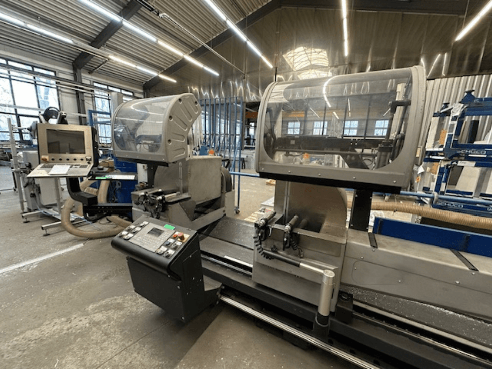 Pilarka tarczowa do metalu SCHÜCO PDG E CUT, widok z przodu, z panelem sterowania, osłonami ochronnymi i obszarem cięcia w warunkach warsztatowych.