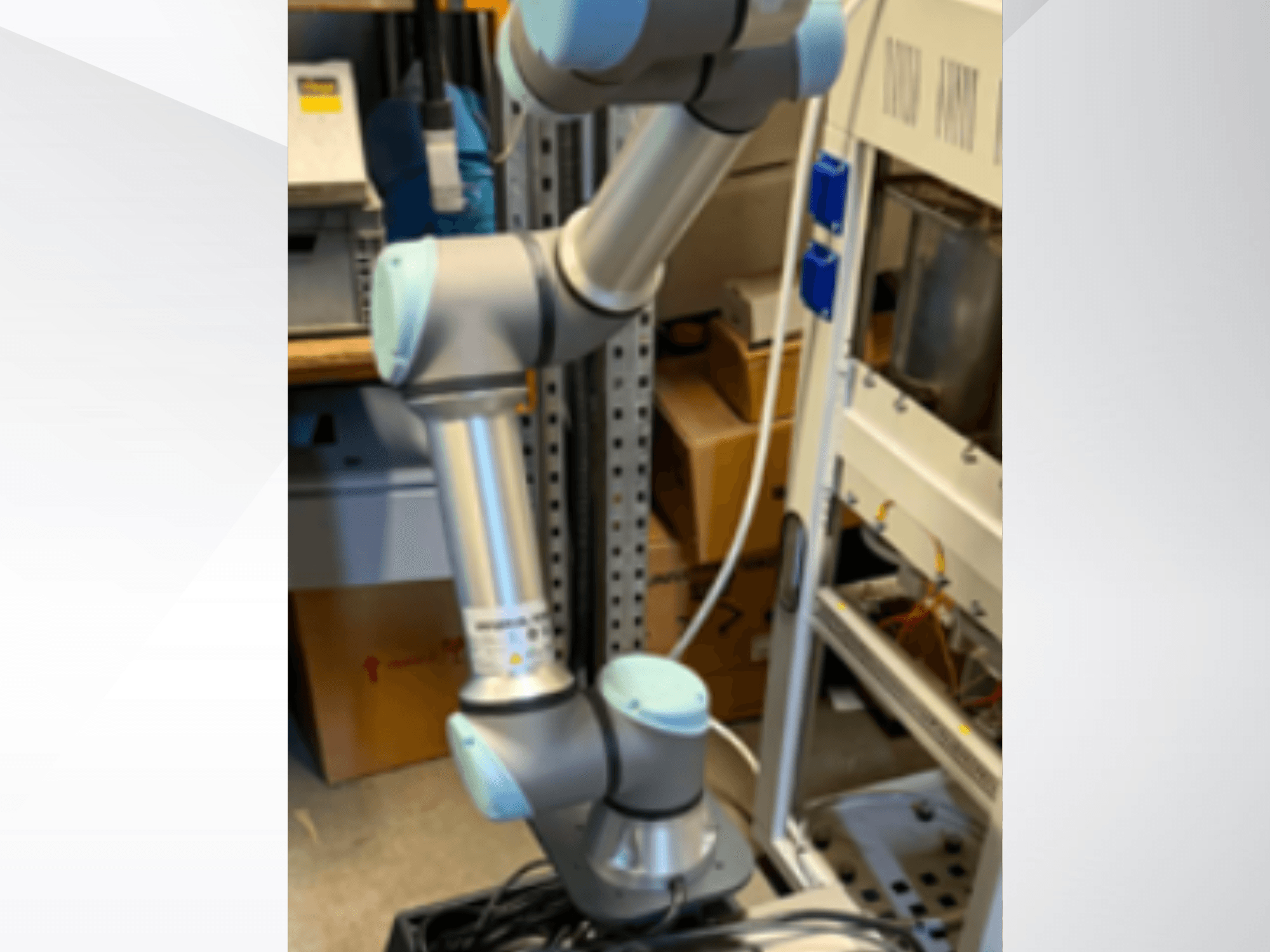Ramię robota UR5e firmy Universal Robots widziane z boku, ukazujące przeguby, lekką konstrukcję oraz kable sterujące.