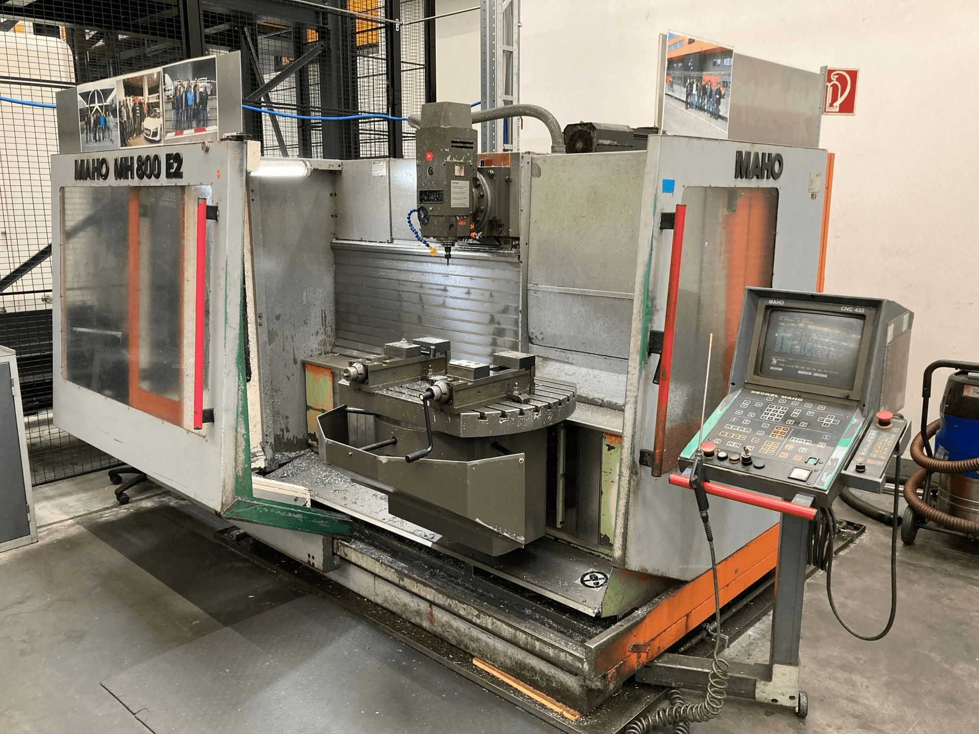 Frezarka CNC Maho MH 800 E2 w widoku z przodu z widocznym panelem sterowania, wrzecionem i stołem roboczym.