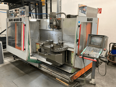 Frezarka CNC Maho MH 800 E2 w widoku z przodu z widocznym panelem sterowania, wrzecionem i stołem roboczym.