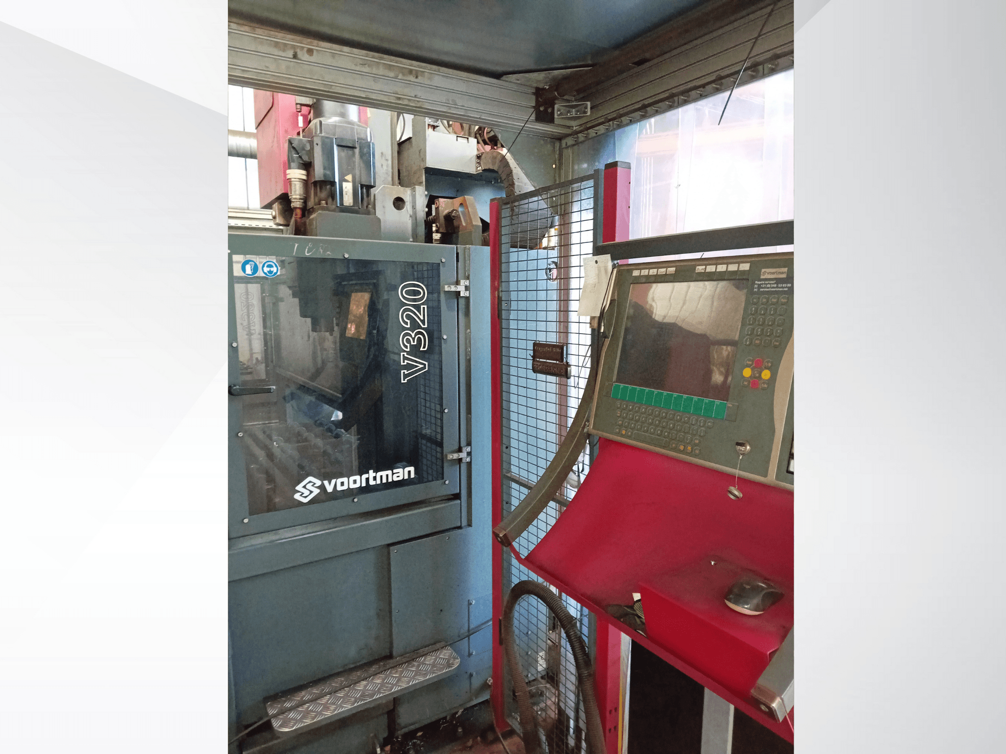 Widok z przodu maszyny CNC Voortman V320 z panelem sterowania z przyciskami, ekranem wyświetlacza i siatkową obudową bezpieczeństwa.