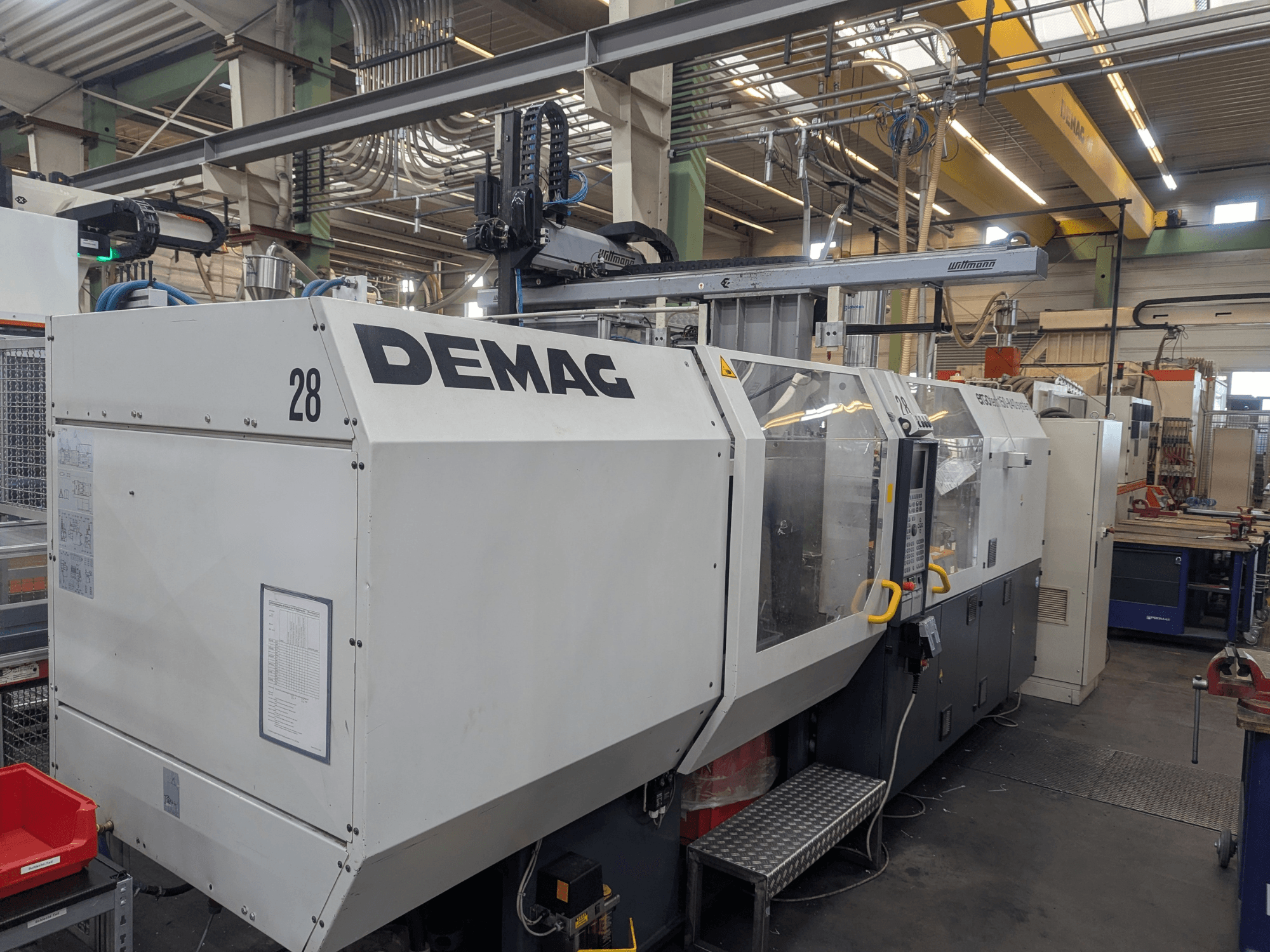 Widok z przodu hydraulicznej wtryskarki DEMAG ERGOTECH 1500-840, przedstawiający elementy sterujące i funkcje bezpieczeństwa.
