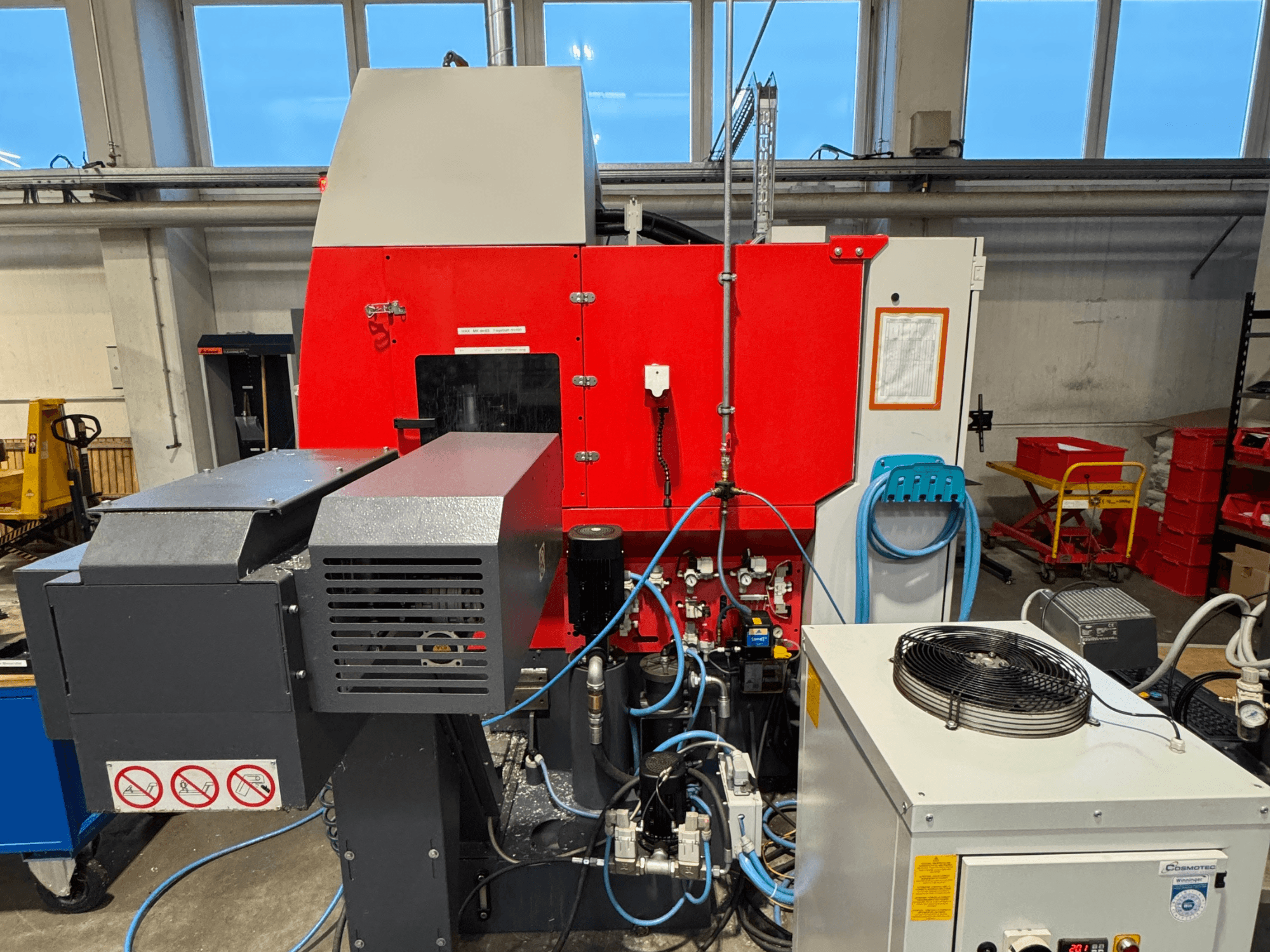 Pionowe centrum obróbcze EMCO MAXXMILL 350, widok z przodu, prezentujące złożone maszyny i szczegóły panelu sterowania.