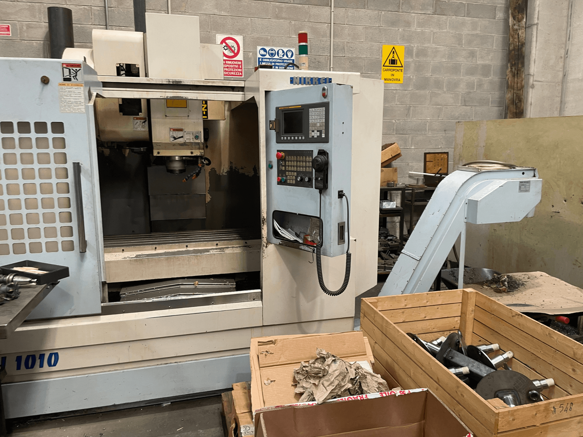 Pionowe centrum obróbcze firmy Other, model VH-1010, widziane od przodu z widocznymi elementami sterującymi i skrzynkami w pobliżu.