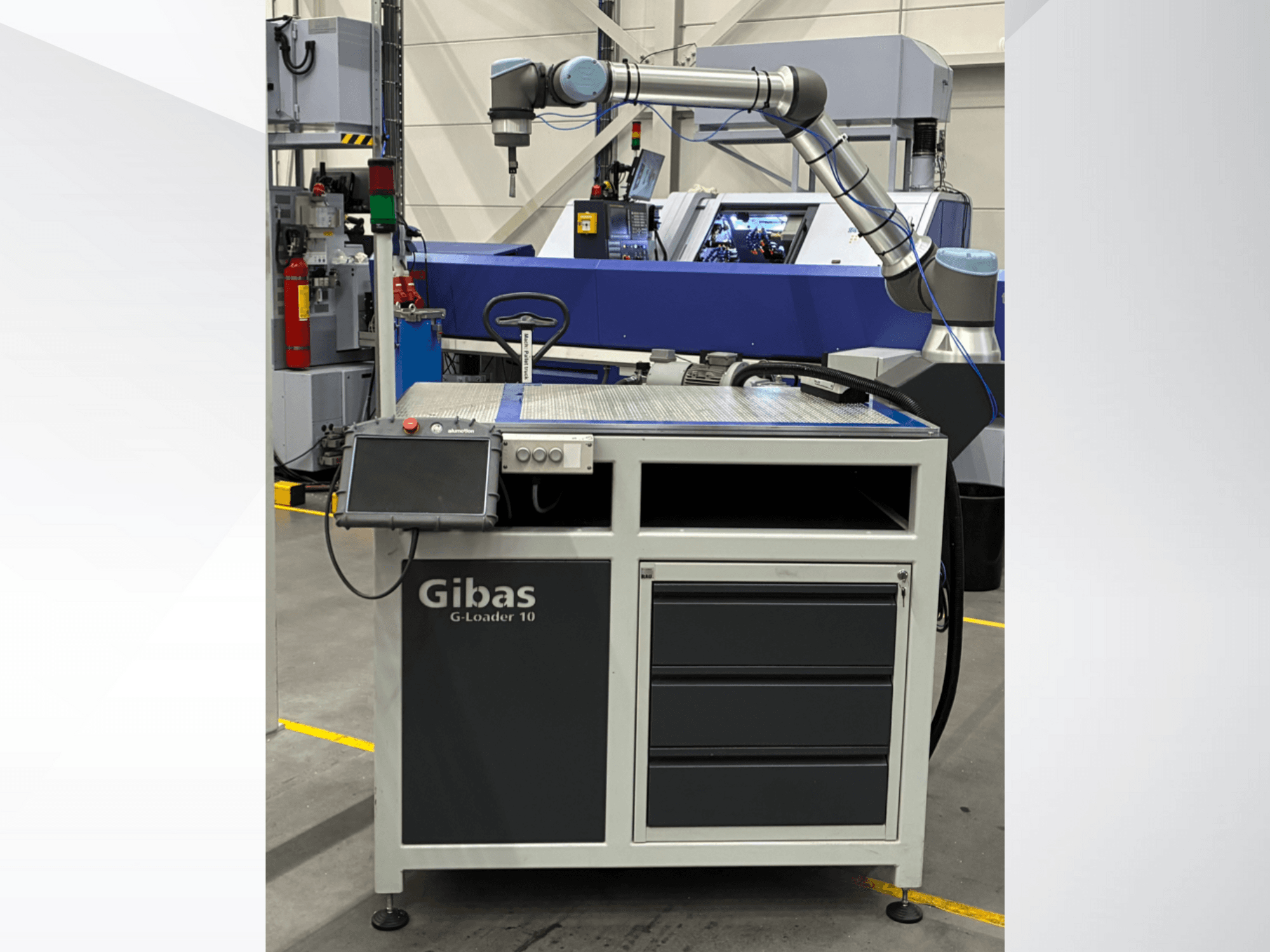 Gibas G-Loader 10 z ramieniem robotycznym, widok z przodu; wyposażony w ekran dotykowy i szufladę do przechowywania w warunkach przemysłowych.