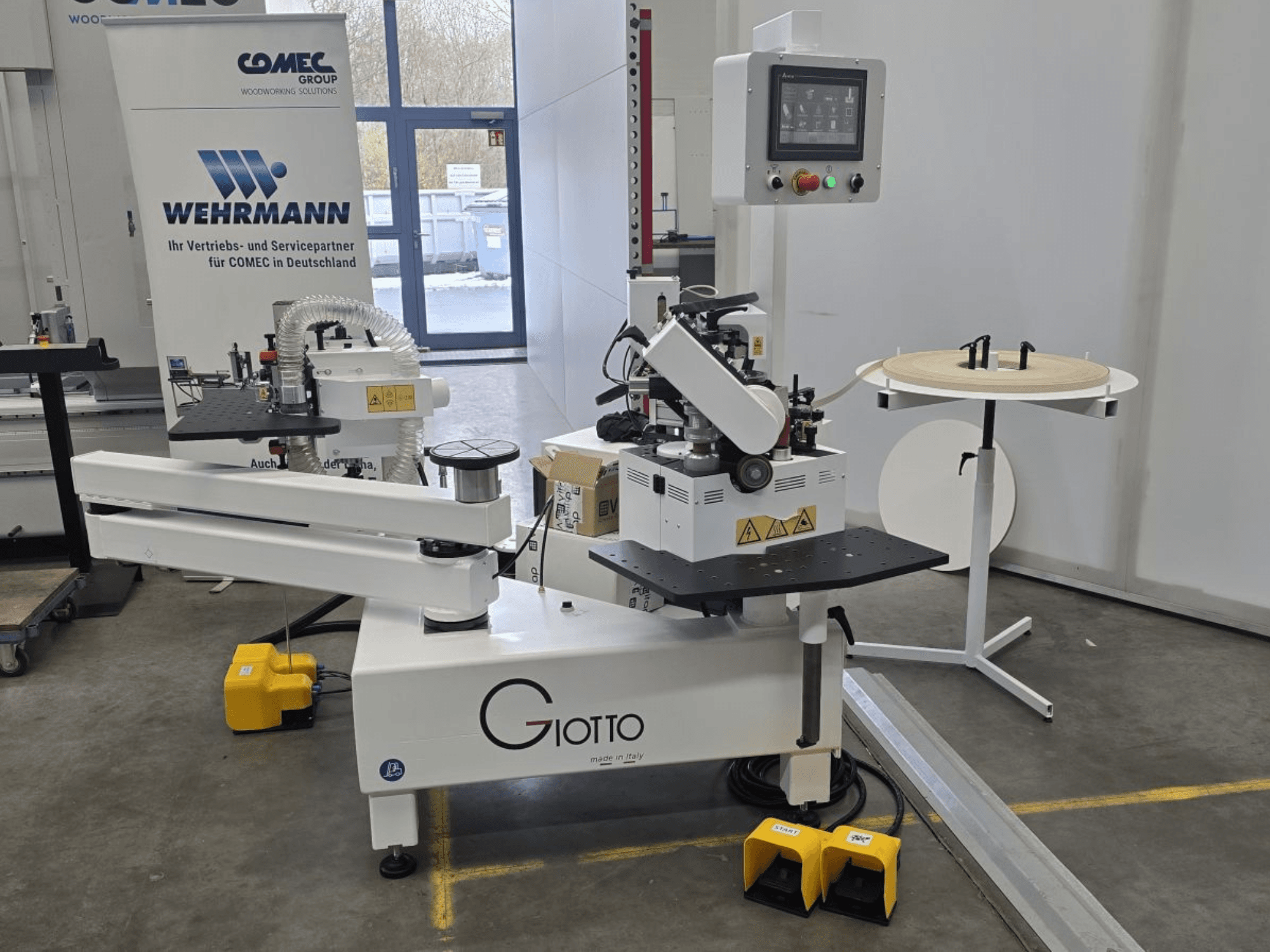 Maszyna do obróbki drewna Giotto z panelem sterowania, widok z boku, zawiera pedały nożne i obrotową powierzchnię roboczą.