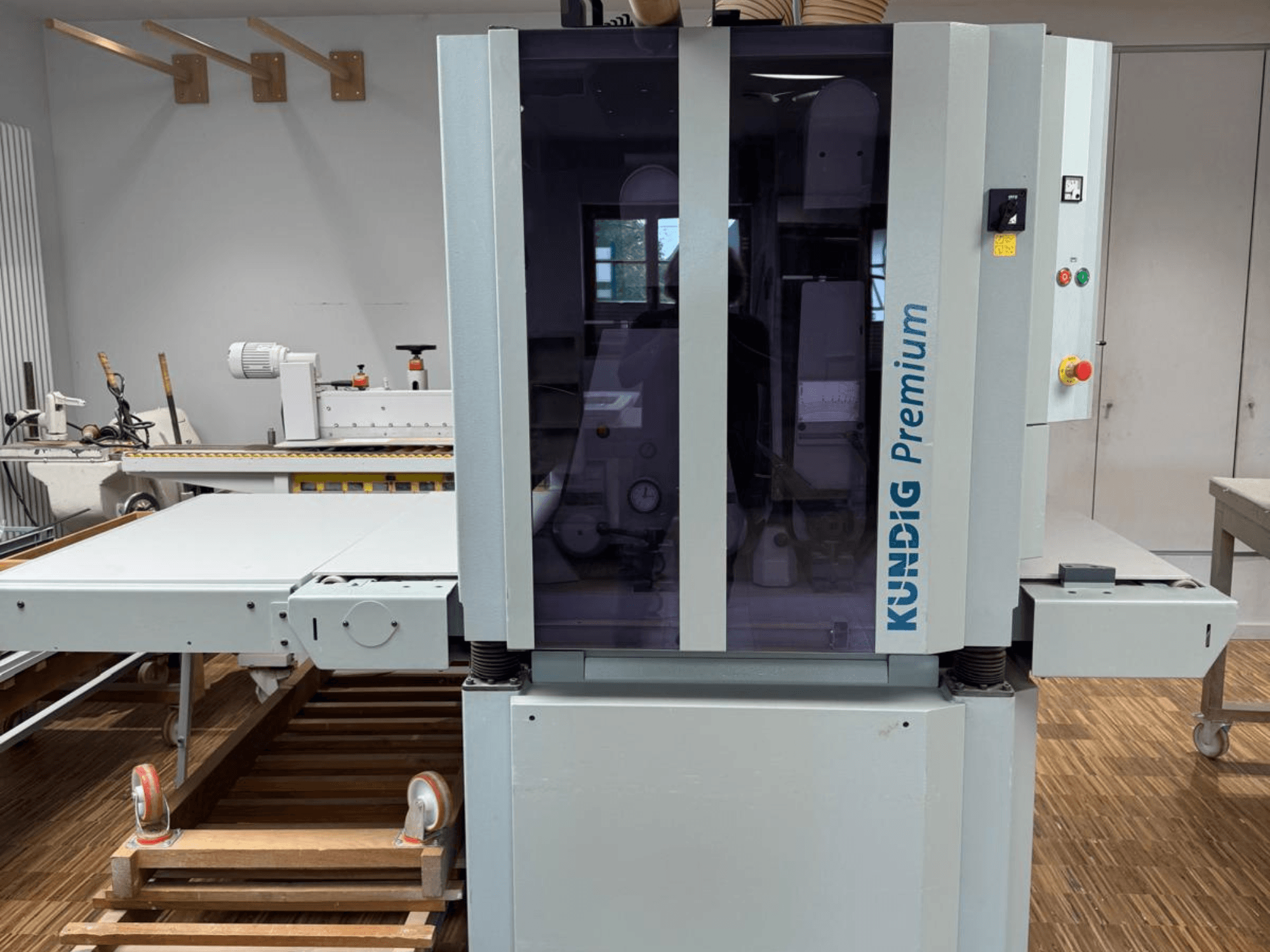 Szlifierka taśmowa Kundig Premium 2-1100-RP w widoku z przodu z panelem sterowania i dużą szklaną obudową zapewniającą widoczność.