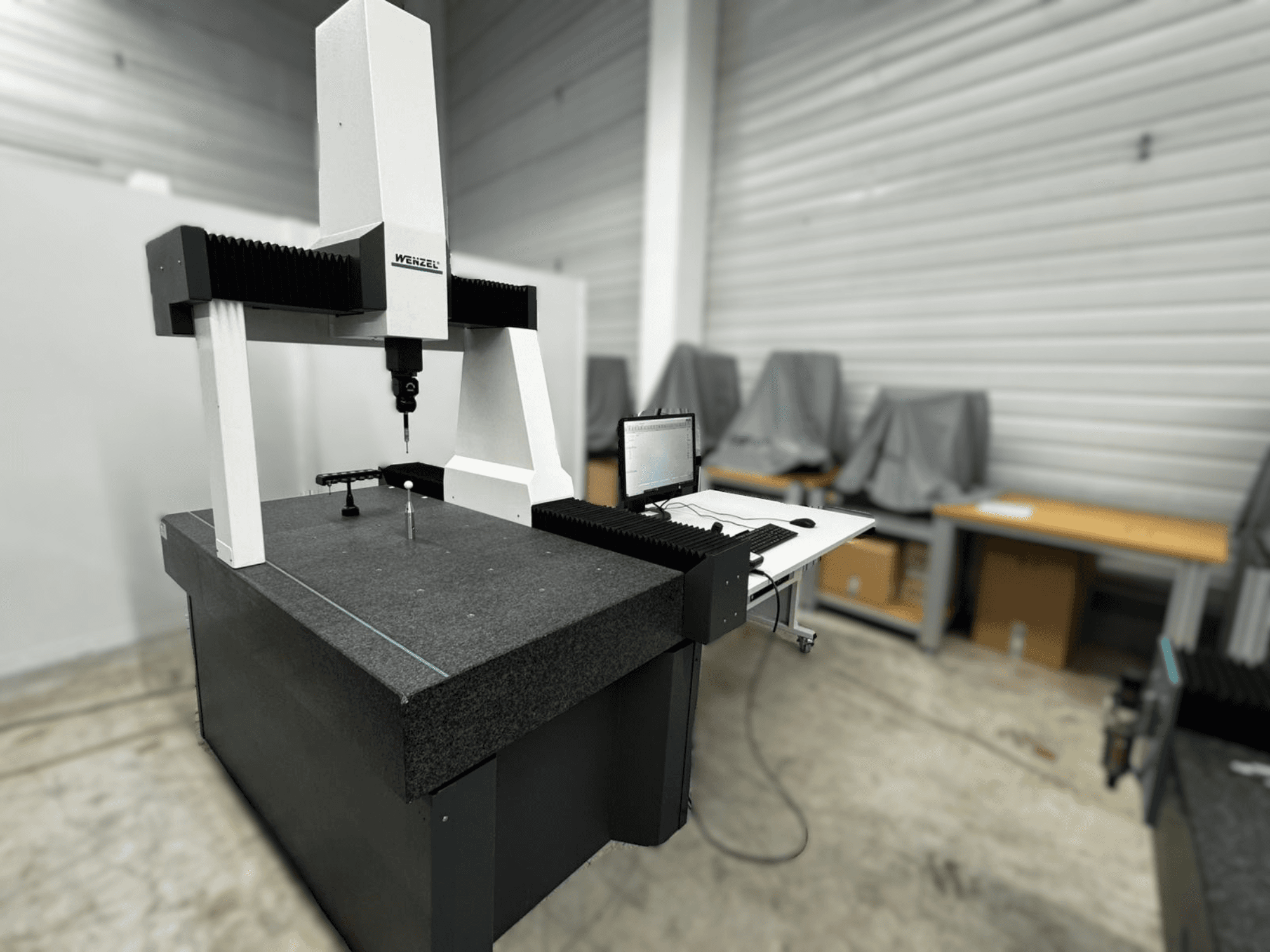 Współrzędnościowa maszyna pomiarowa Wenzel LH 54 w widoku z boku, z sondą i interfejsem komputerowym na szarej podstawie.